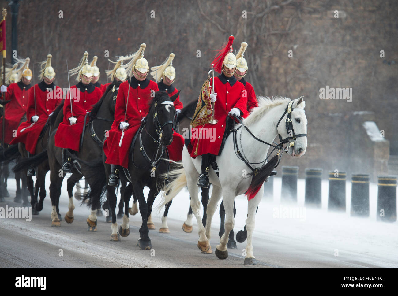 1 marzo 2018. Vita delle guardie corsa attraverso il vento la neve soffiata a frequentare la modifica della cerimonia di guardia presso la sfilata delle Guardie a Cavallo, Londra, Regno Unito. Foto Stock