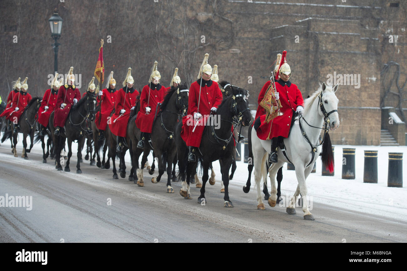 1 marzo 2018. Vita delle guardie corsa attraverso il vento la neve soffiata a frequentare la modifica della cerimonia di guardia presso la sfilata delle Guardie a Cavallo, Londra, Regno Unito. Foto Stock