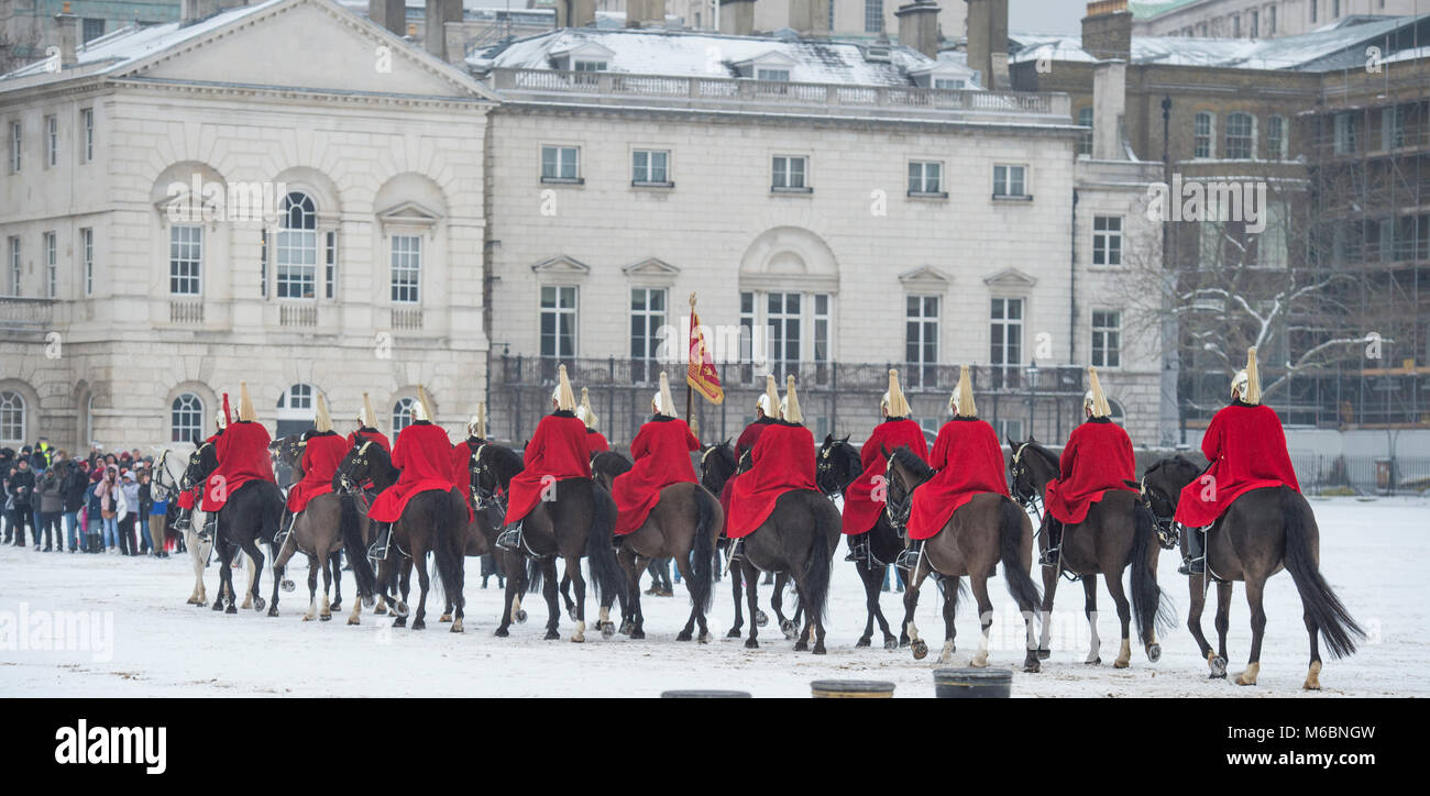 1 marzo 2018. Vita delle guardie corsa attraverso il vento la neve soffiata a frequentare la modifica della cerimonia di guardia presso la sfilata delle Guardie a Cavallo, Londra, Regno Unito. Foto Stock
