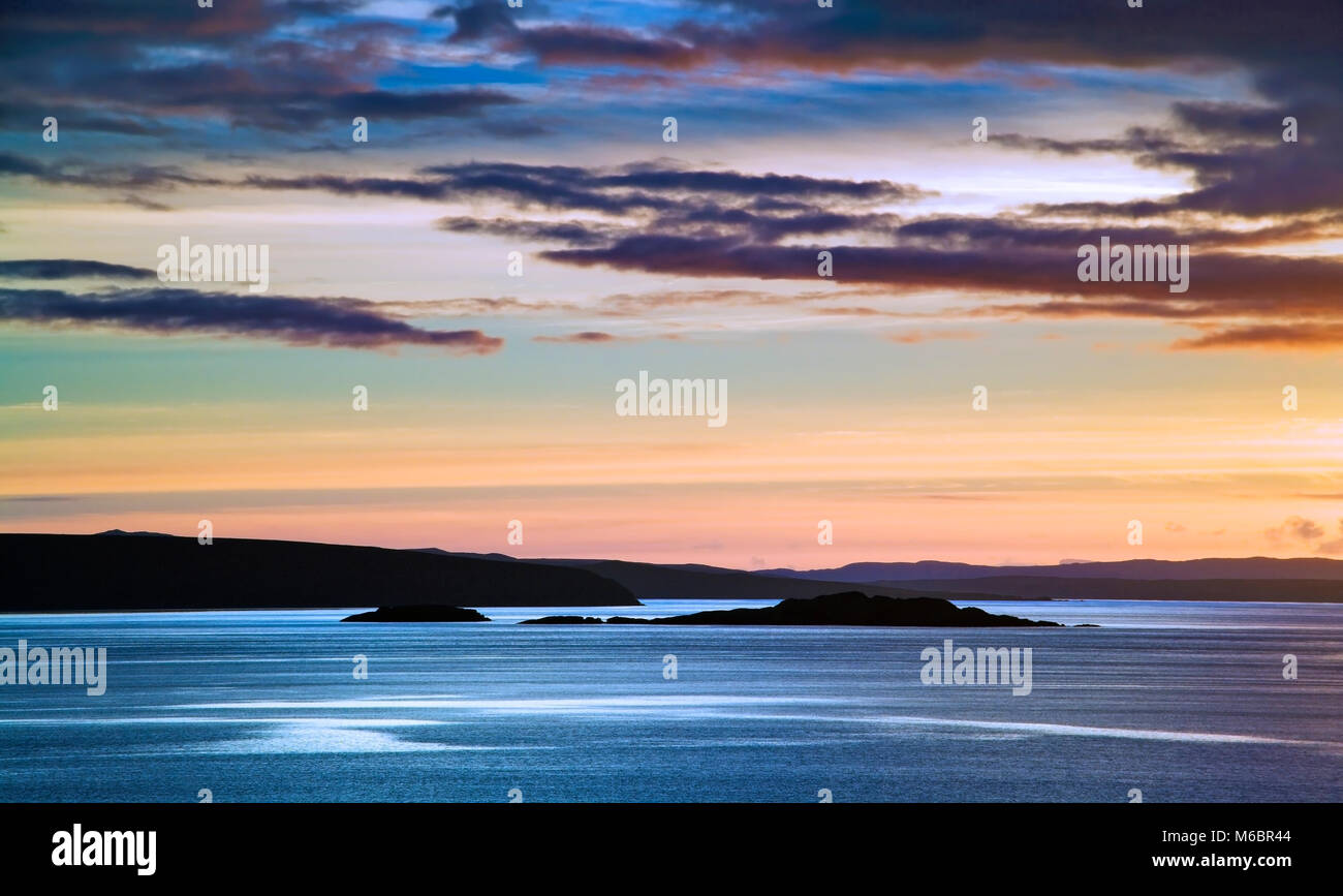 Una vista di un tramonto sul telecomando estate isole lungo la costa occidentale della Scozia. Foto Stock