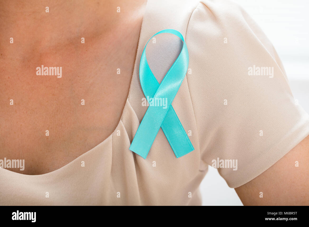 Close-up di una donna con nastro di Teal per supportare la consapevolezza cervicale Foto Stock