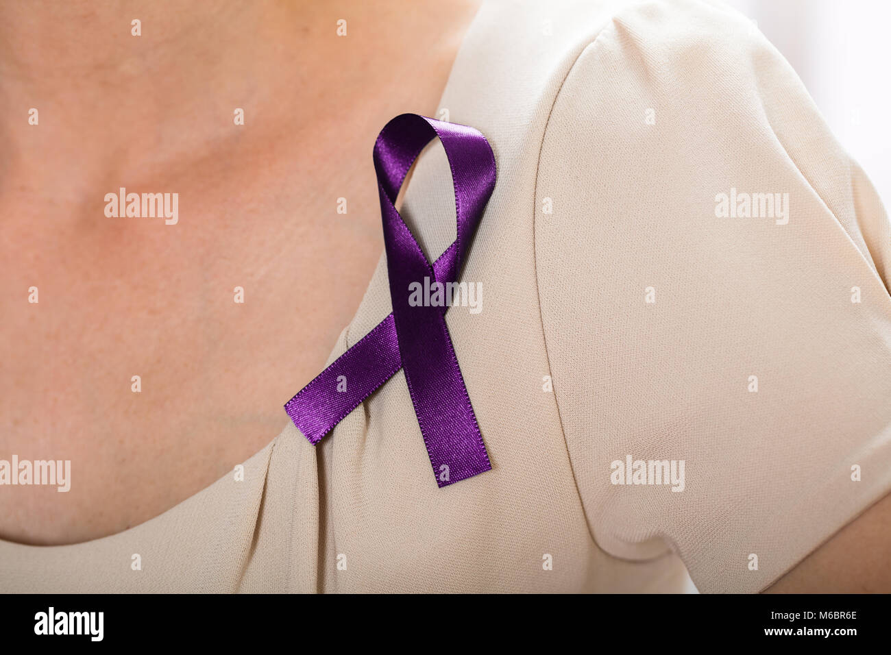 Close-up di una donna con nastro viola per il supporto di cancro testicolare consapevolezza Foto Stock