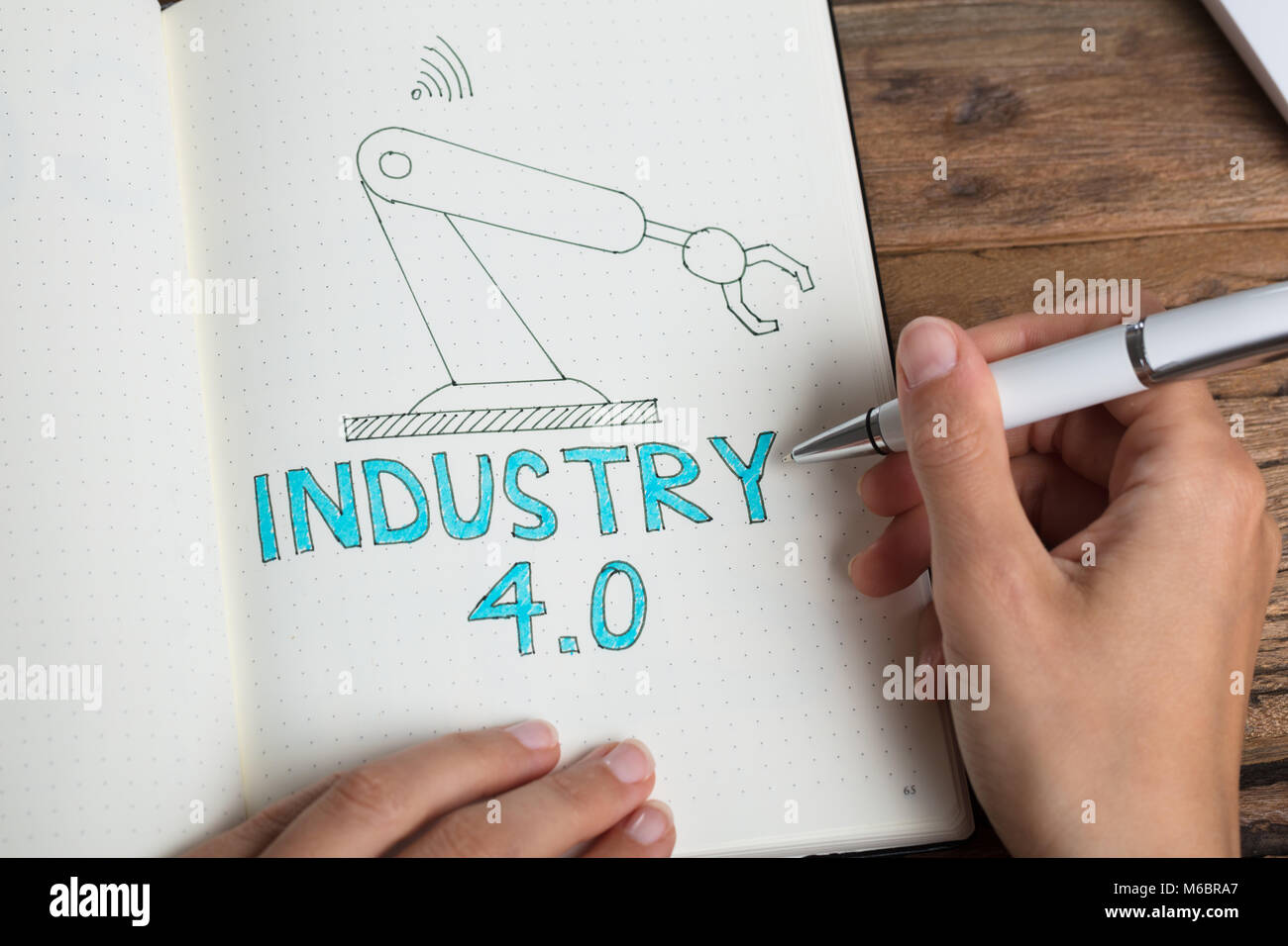 Angolo di Alta Vista di una mano umana industria di disegno 4.0 concetto su Notebook Foto Stock