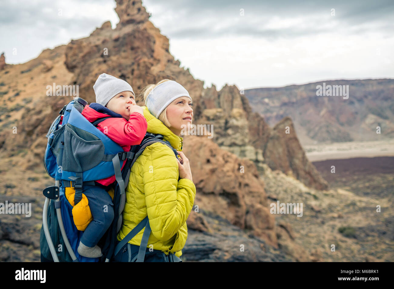 Escursione di famiglia baby boy viaggia nella madre di zaino. Avventura Trekking con bambino in autunno viaggio con la famiglia in montagna. Vacanze Viaggio con bambino ca Foto Stock