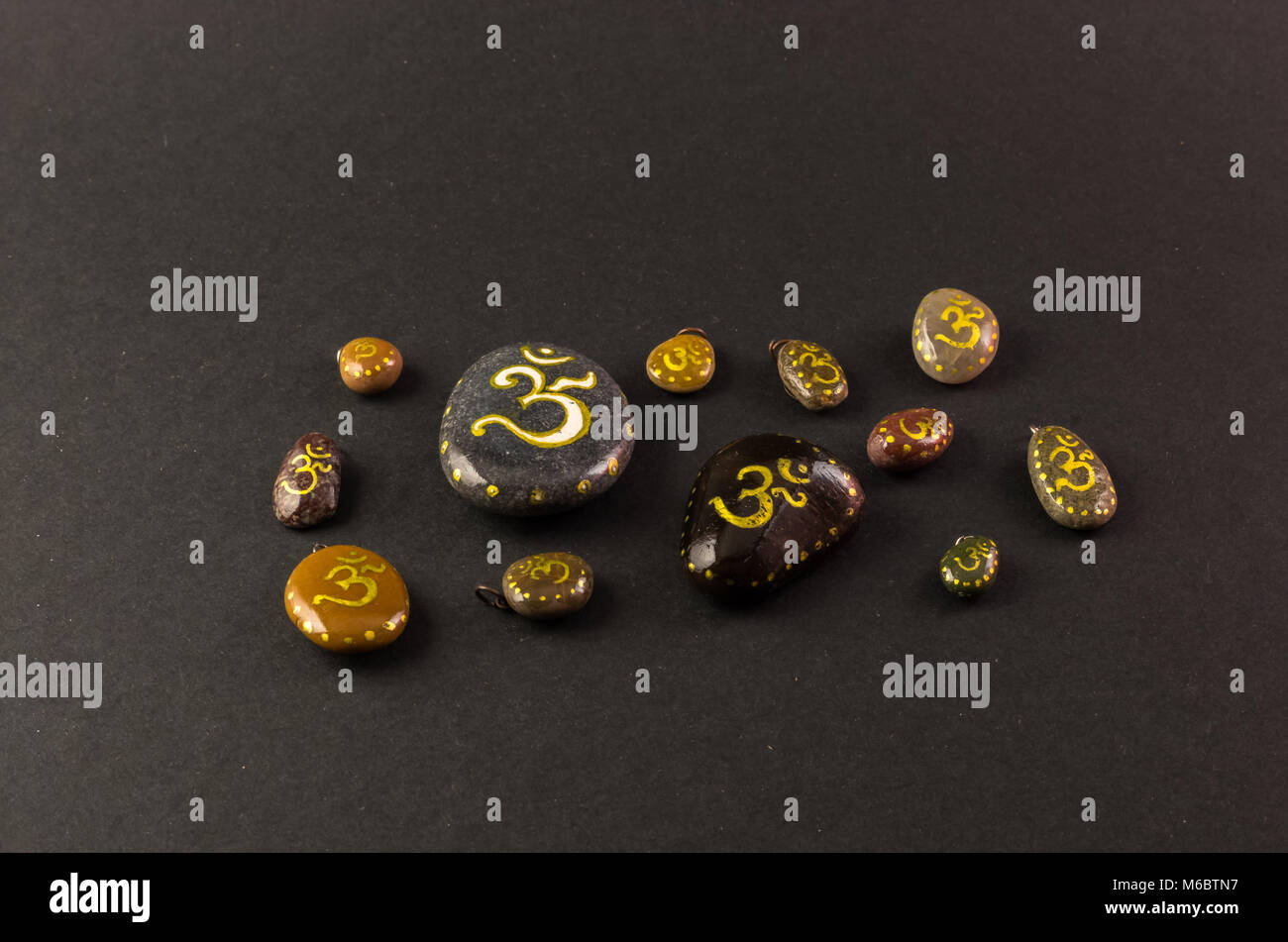 Le pietre colorate dipinte con simbolo Om Foto Stock