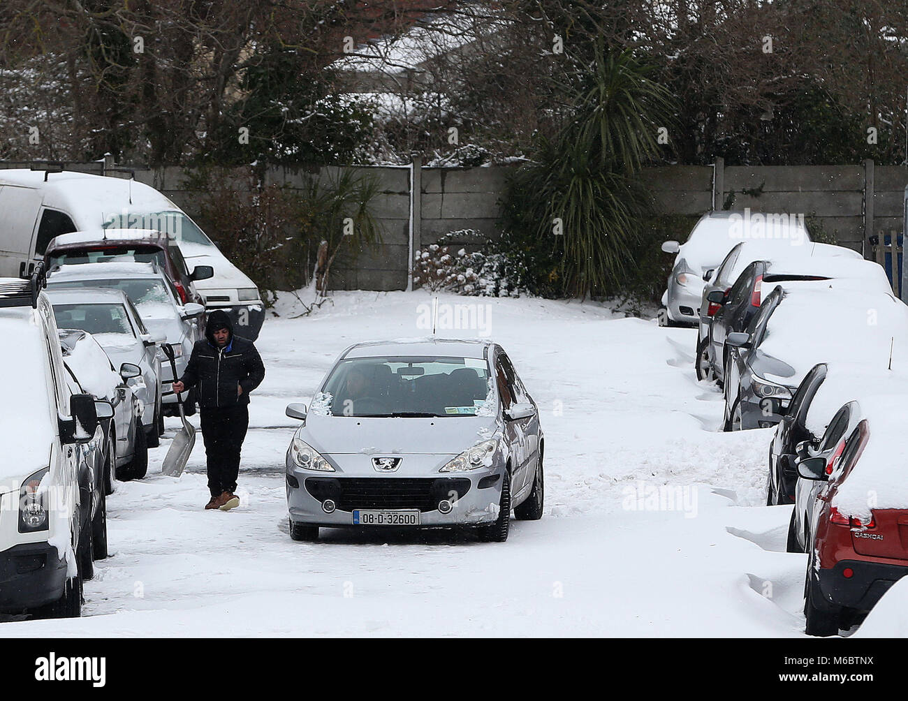 Un uomo che porta una pala da neve dopo aver aiutato per cancellare un percorso di vetture a Drumcondra, Dublino, come le condizioni climatiche severe continuare. Picture Data: Venerdì 2 Marzo, 2018. Vedere PA storia meteo neve in Irlanda. Foto di credito dovrebbe leggere: Brian Lawless/PA FILO Foto Stock