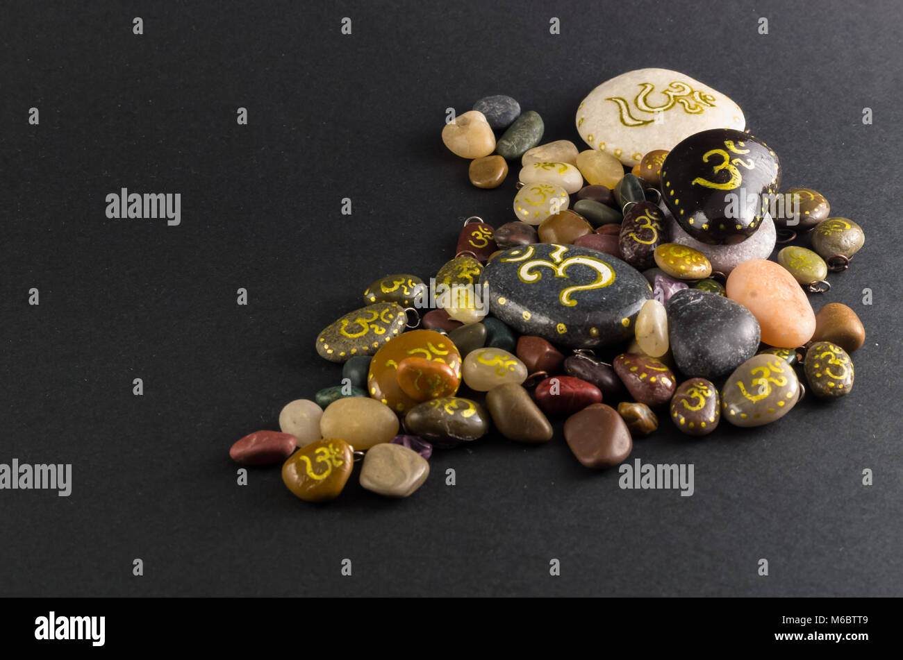 Pila di poco pietre decorative dipinte con simbolo Om Foto Stock