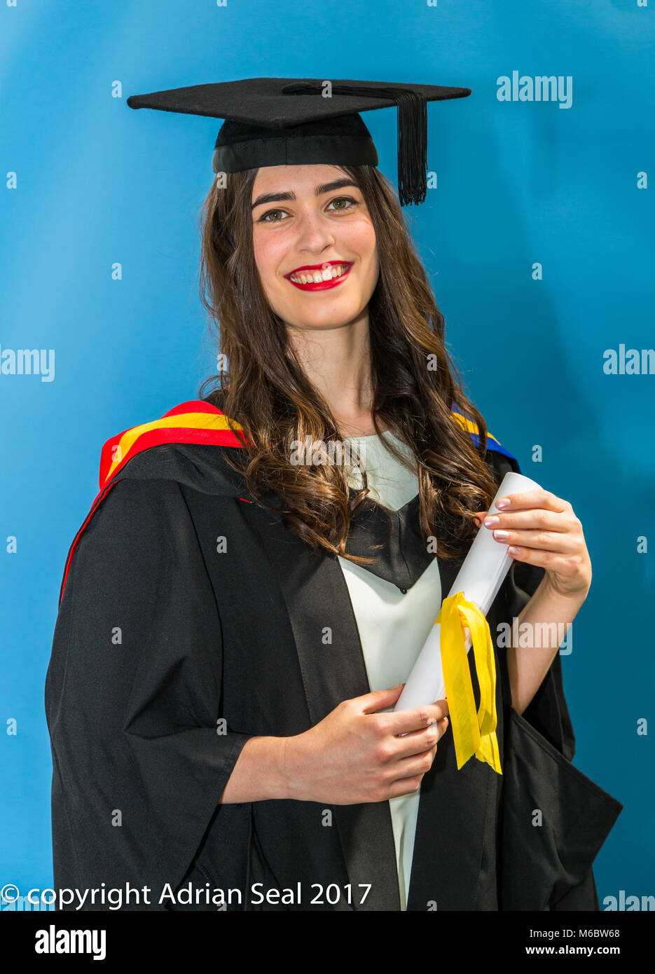 Un felice e sorridente giovane donna, presso una università cerimonia di laurea a Londra, Inghilterra, Regno Unito Foto Stock