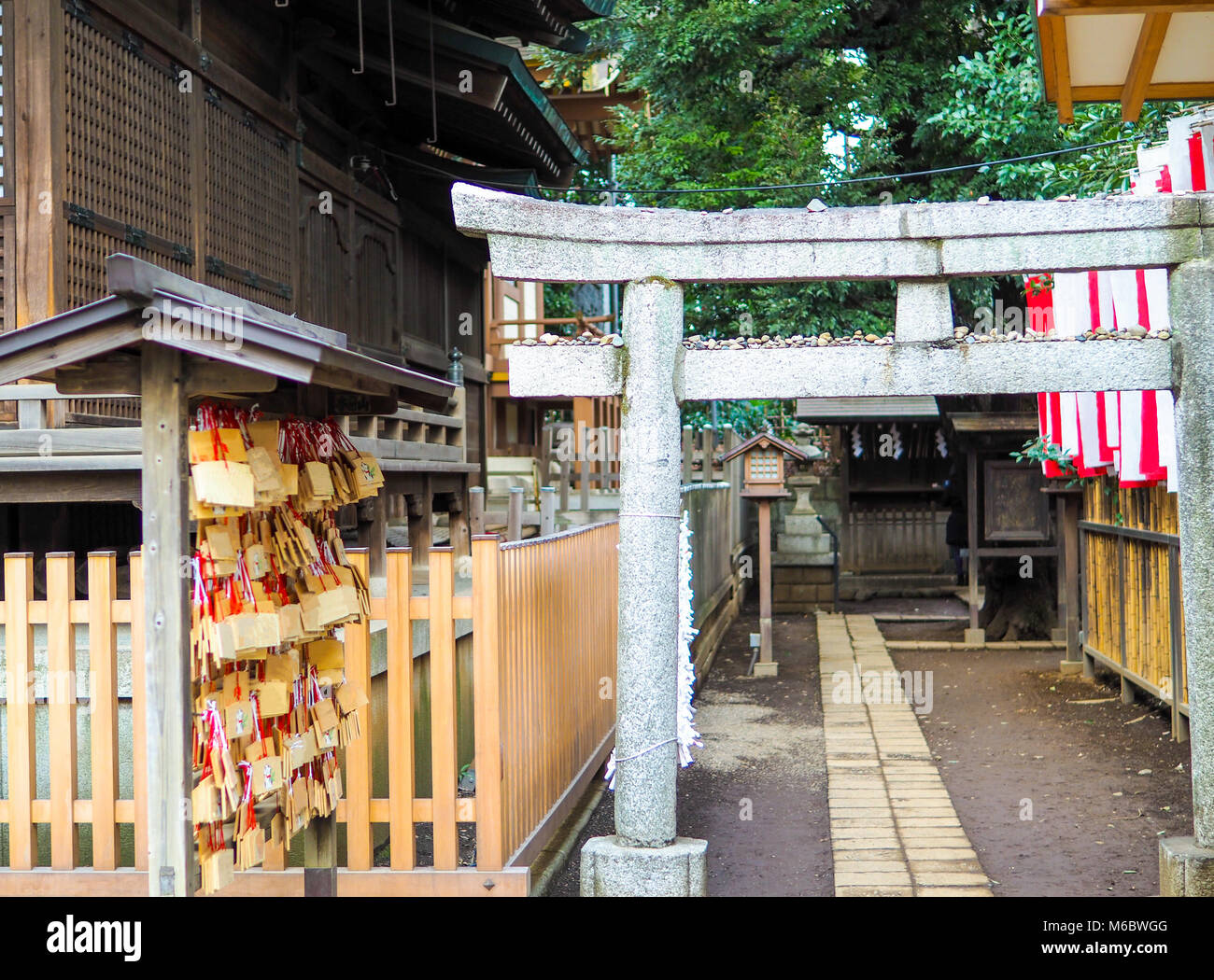 Lo Shintoismo shine piccolo cortile interno in Tokyo, Giappone. Sulla sinistra sono le placche di preghiera denominato Ema. Cancello di ingresso e più piccolo santuario nel centro.Tutto il testo rimosso. Foto Stock