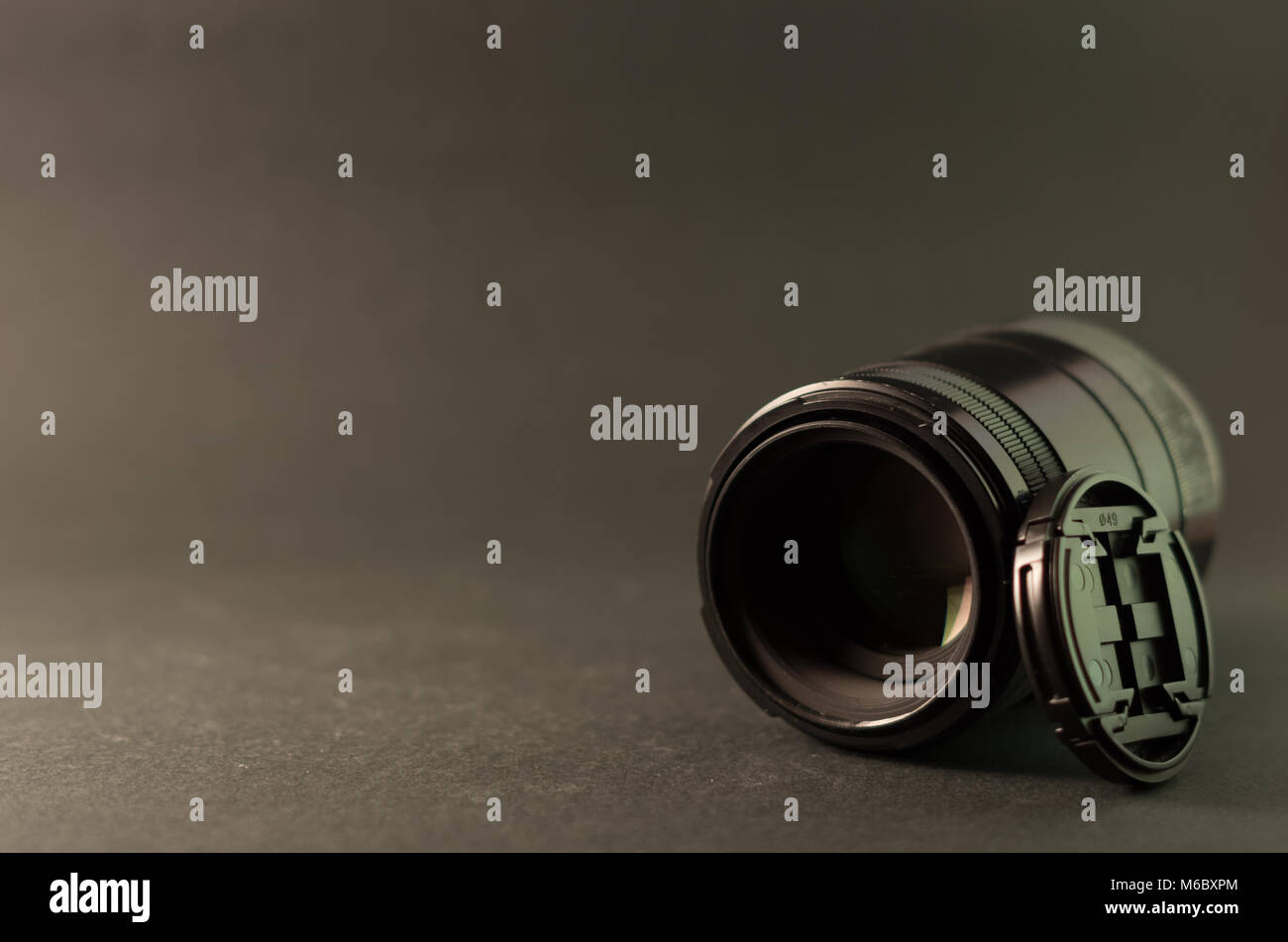 Lenti macro e copriobiettivo su sfondo grigio Foto Stock