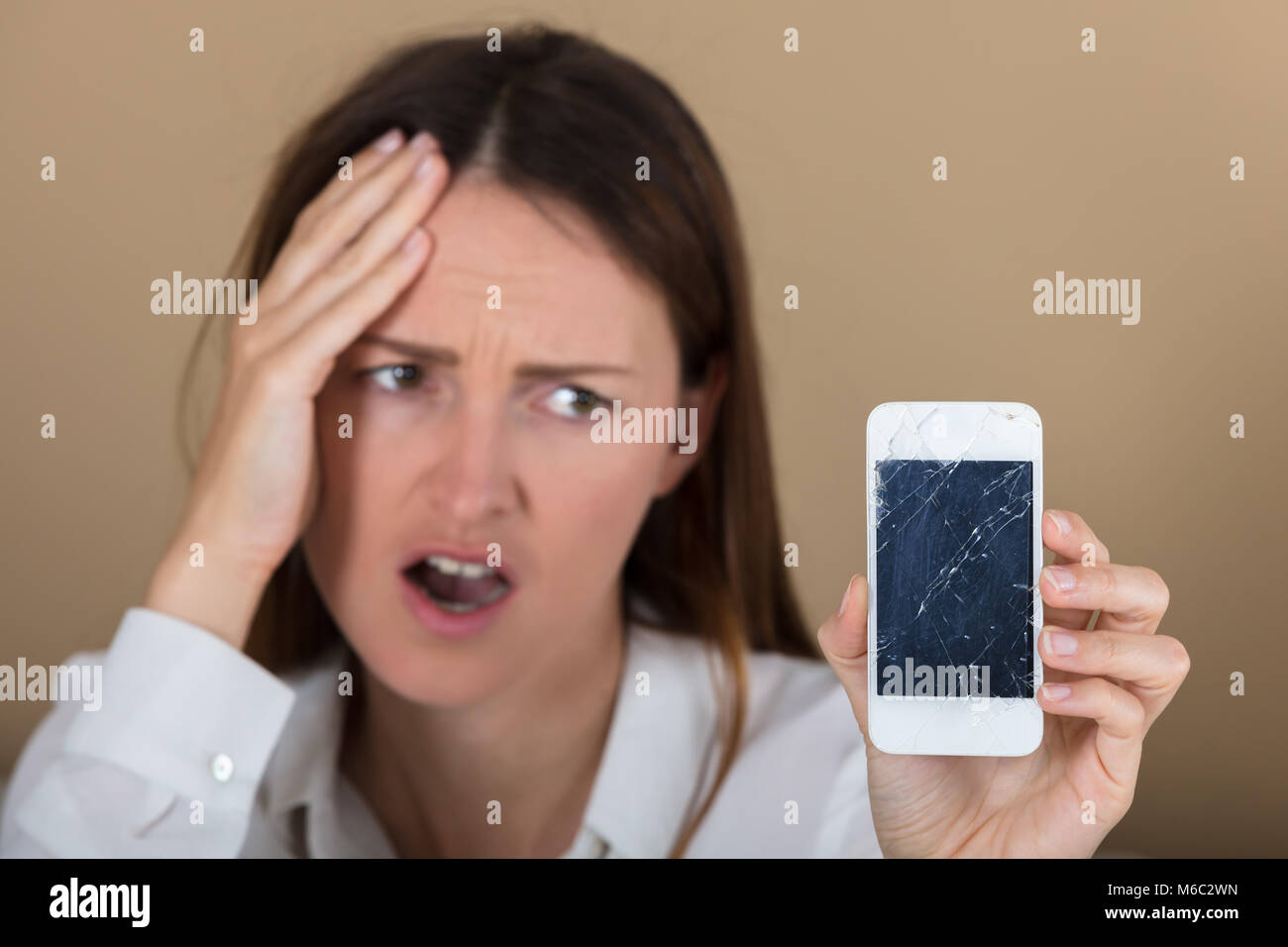 Close-up di donna infelice Azienda Smart Phone con schermo incrinato Foto Stock