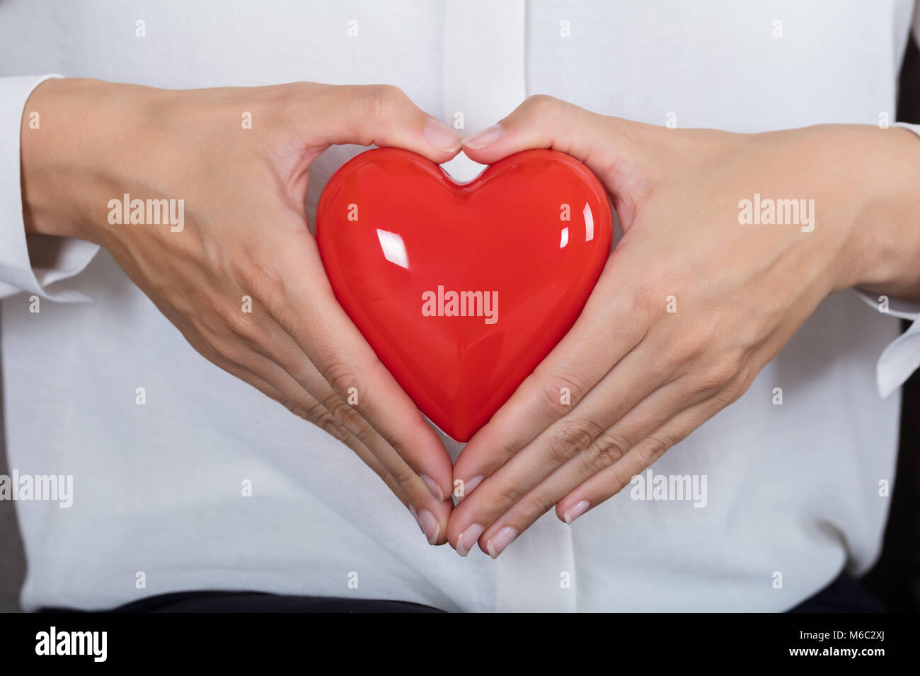 Close-up di una donna tenendo cuore rosso Foto Stock