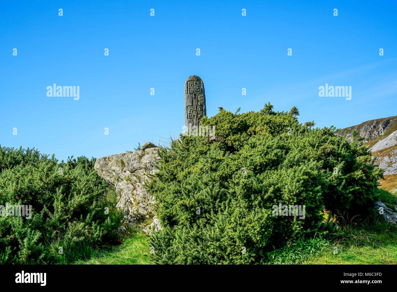 La pietra permanente è chiamato un Turas è stato creato tra l ottavo e il nono secolo sorge al di fuori della Chiesa di Irlanda in Glencolmcille. Foto Stock