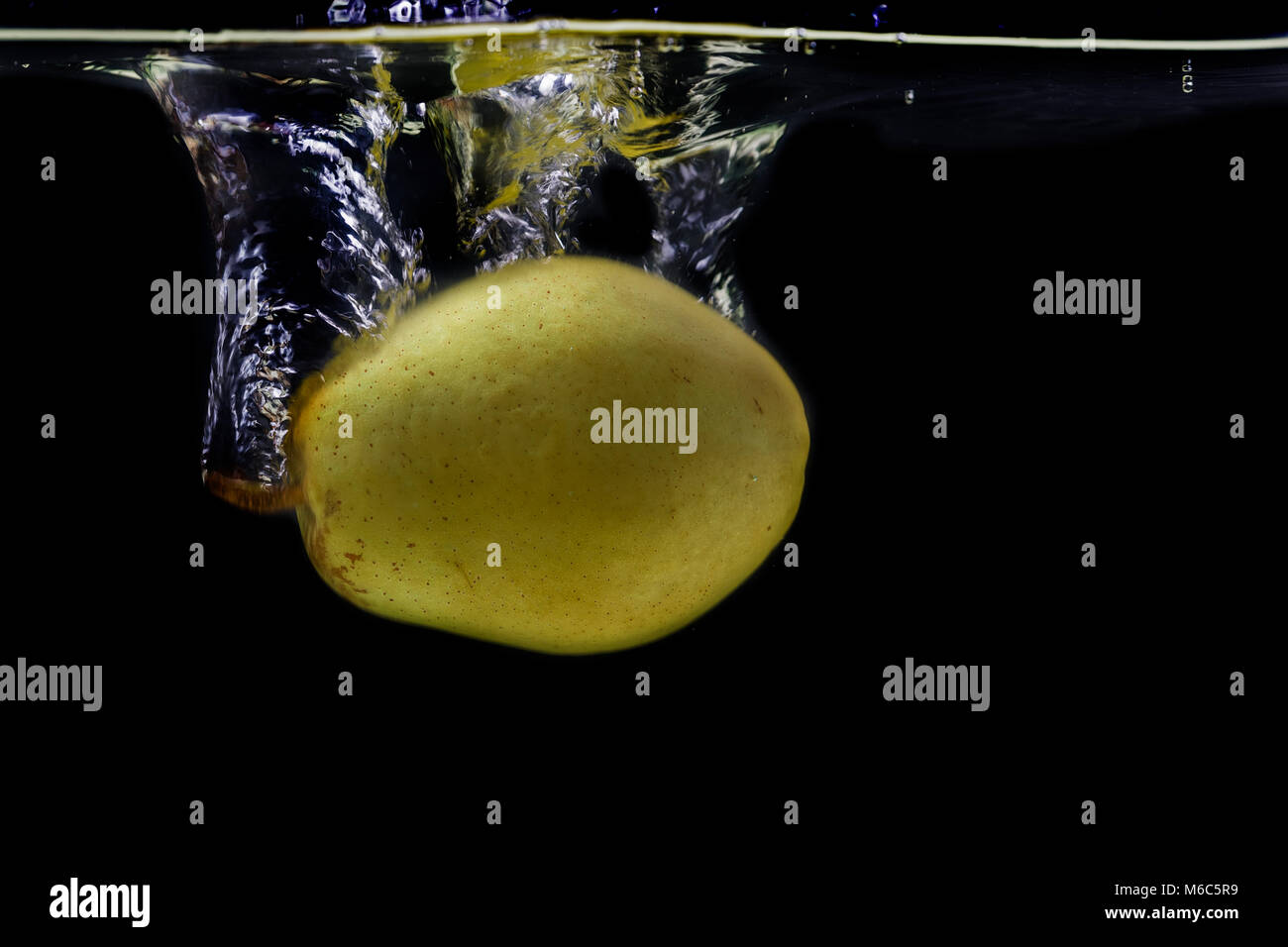 Pera giallo in acqua splash isolati su sfondo nero. Foto Stock