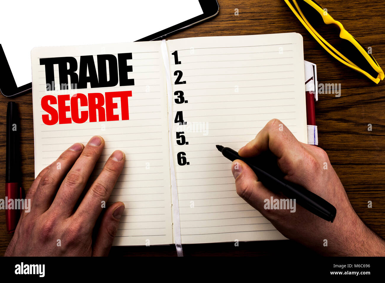 La parola, la scrittura al segreto commerciale. Il concetto di business per la protezione dei dati il libro scritto, sullo sfondo di legno con imprenditore mano, dito scrivendo sul notebook Foto Stock