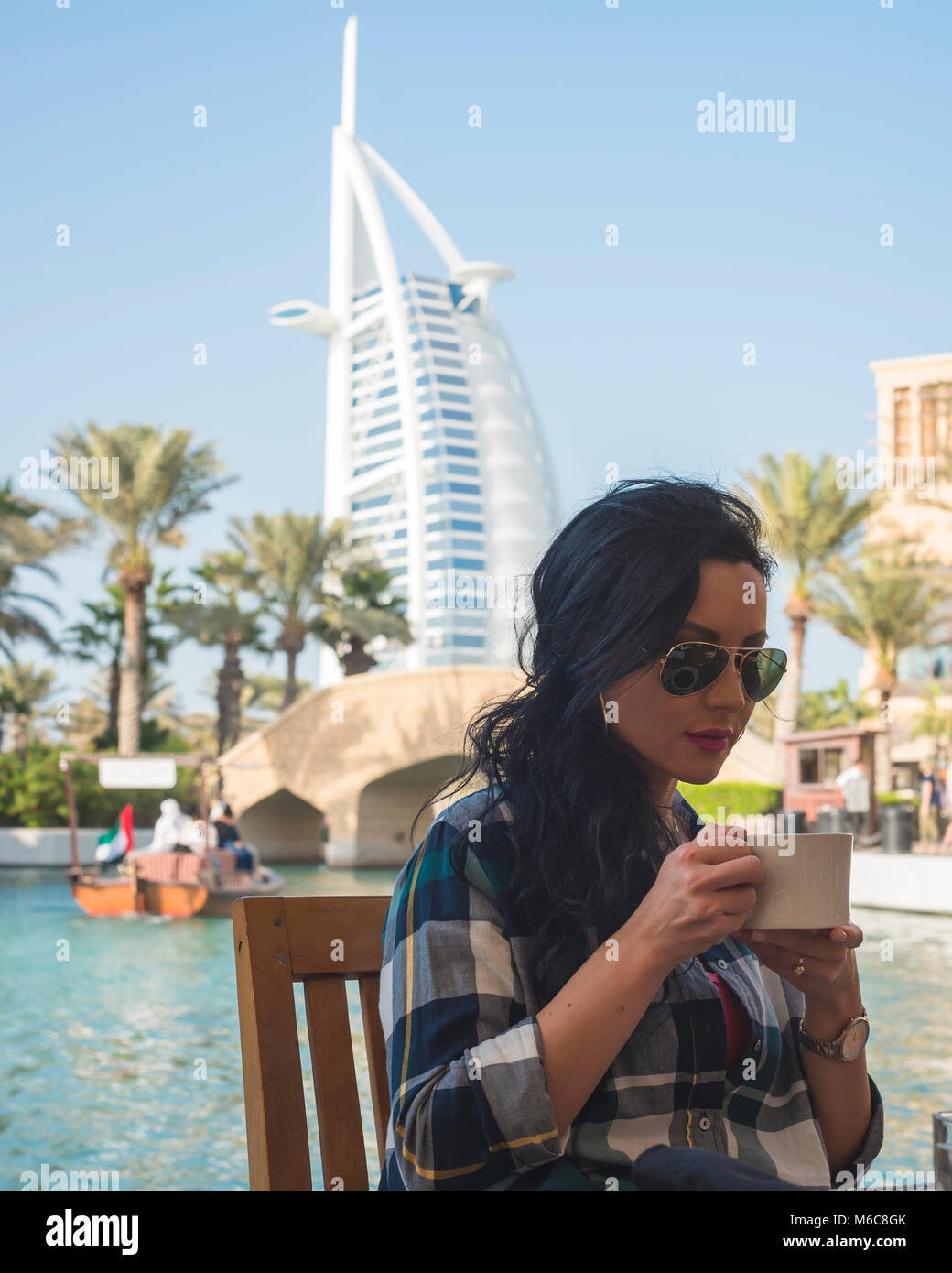 Ragazza di bere il caffè con il burj al arab in background Foto Stock