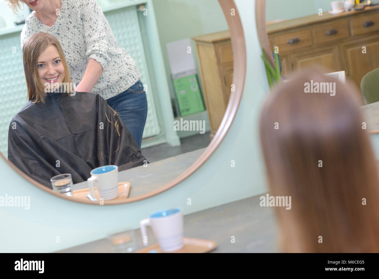 Donna positivo il taglio di capelli di ragazze al salone Foto Stock