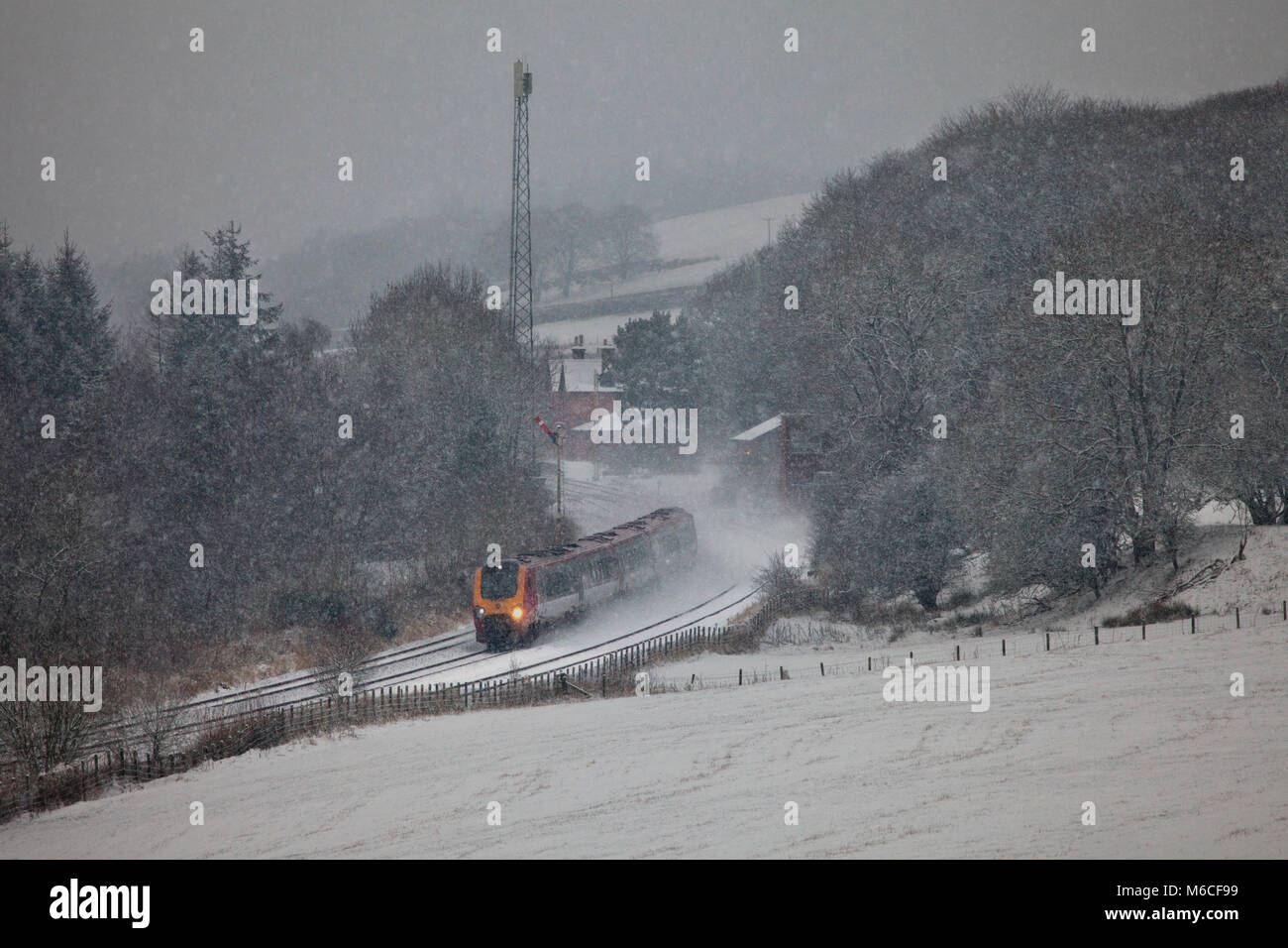 Una Vergine Voyager in treno in una tempesta di neve a Thornhill a nord di Dumfries, il treno è stato deviato a causa di un danneggiamento del ponte sulla linea principale della costa occidentale Foto Stock