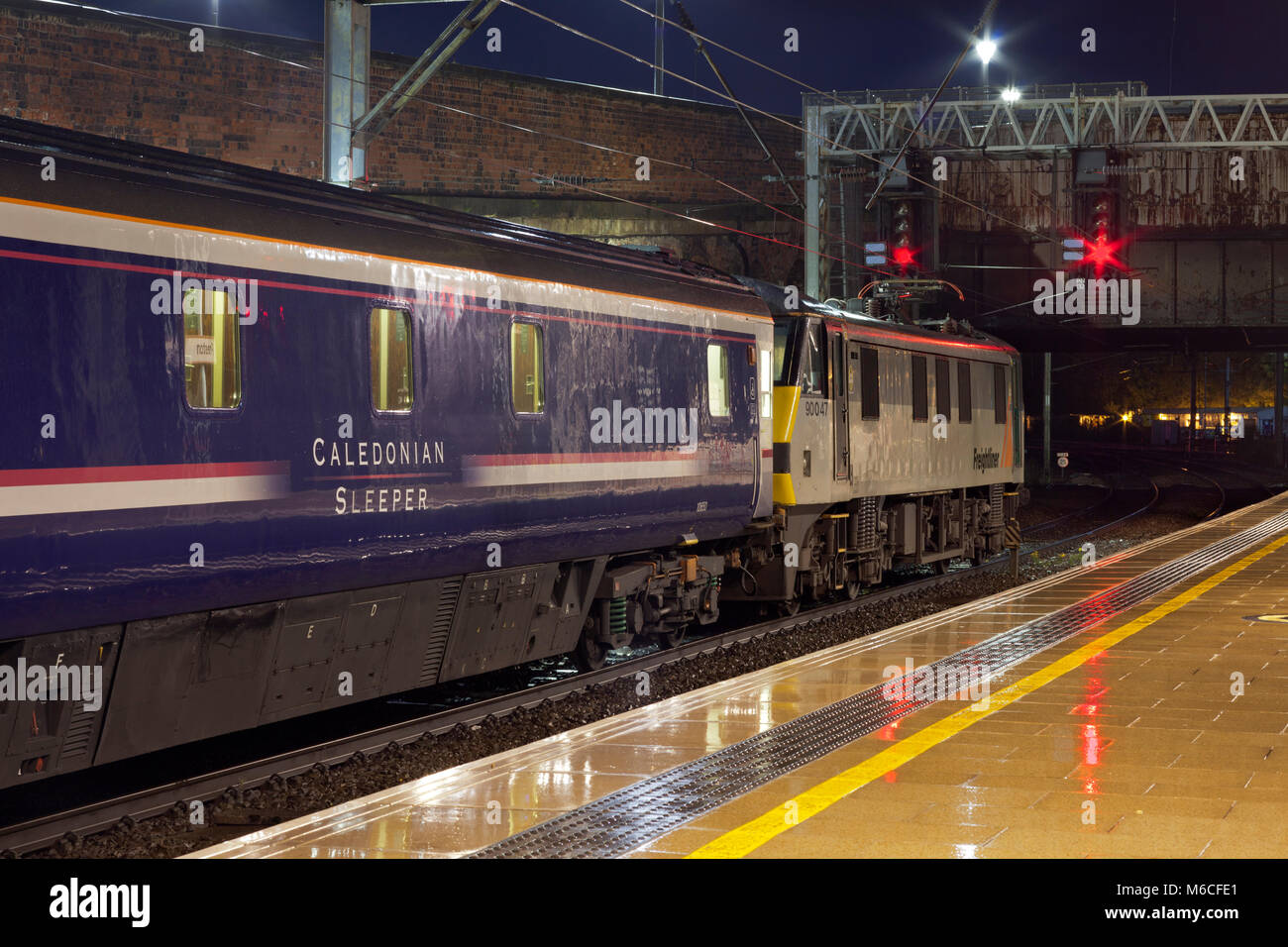 Il 2350 London Euston - Glasgow & Edinburgh Caledonian sleeper attende a Preston presto su un umido del mattino trainati da un freightliner classe 90 locomotore Foto Stock