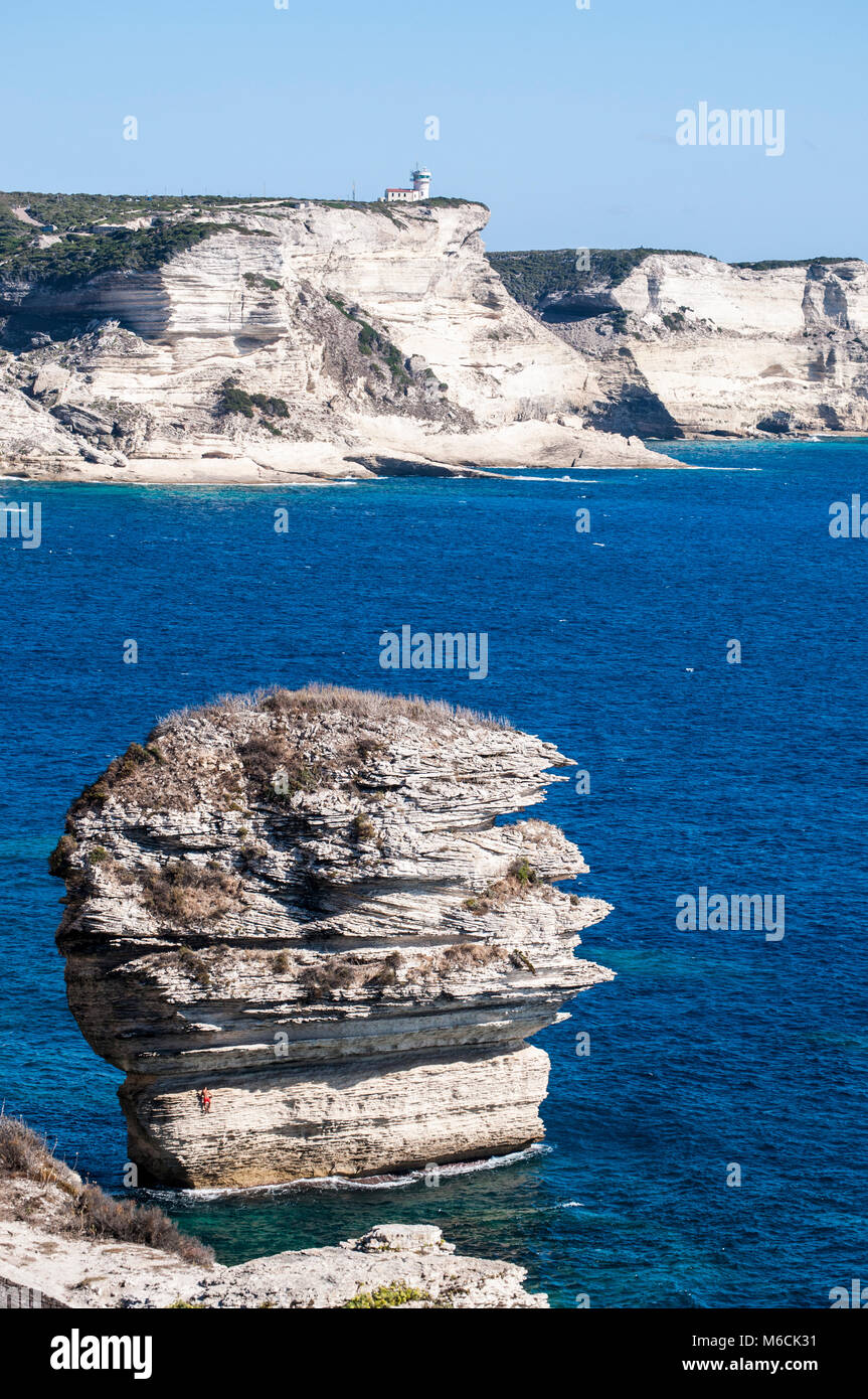 Corsica: la mozzafiato bianche scogliere calcaree nella International Bouches de Bonifacio parco marino con vista del capo Pertusato faro Foto Stock