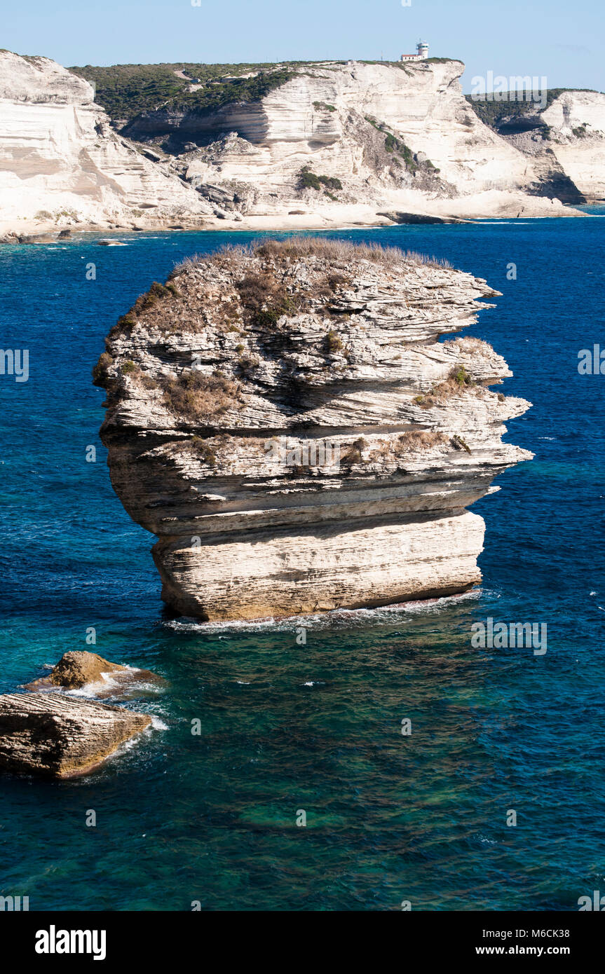 Corsica: la mozzafiato bianche scogliere calcaree nella International Bouches de Bonifacio parco marino con vista del capo Pertusato faro Foto Stock