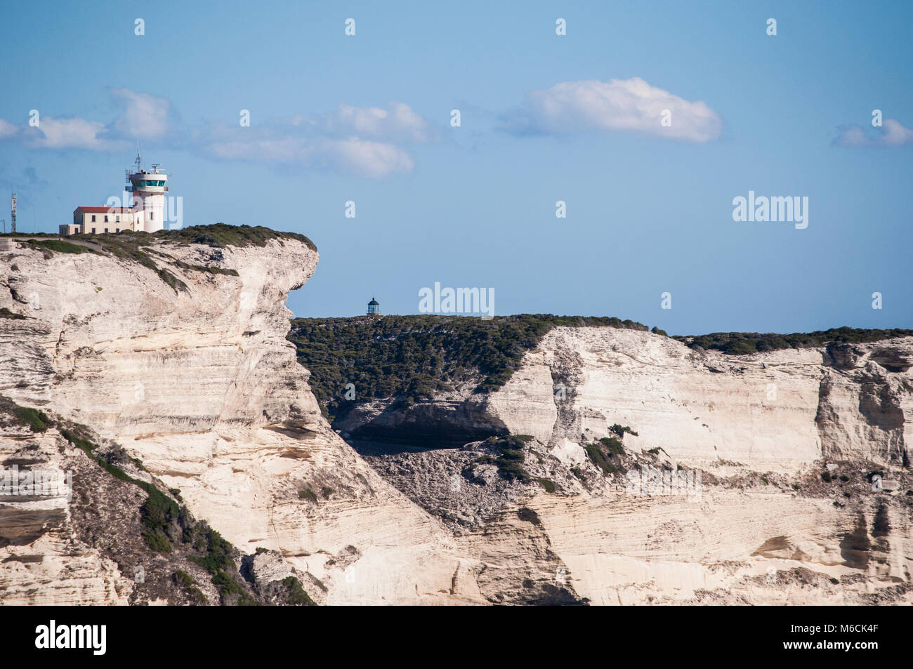 Corsica: la mozzafiato bianche scogliere calcaree nella International Bouches de Bonifacio parco marino con vista del capo Pertusato faro Foto Stock