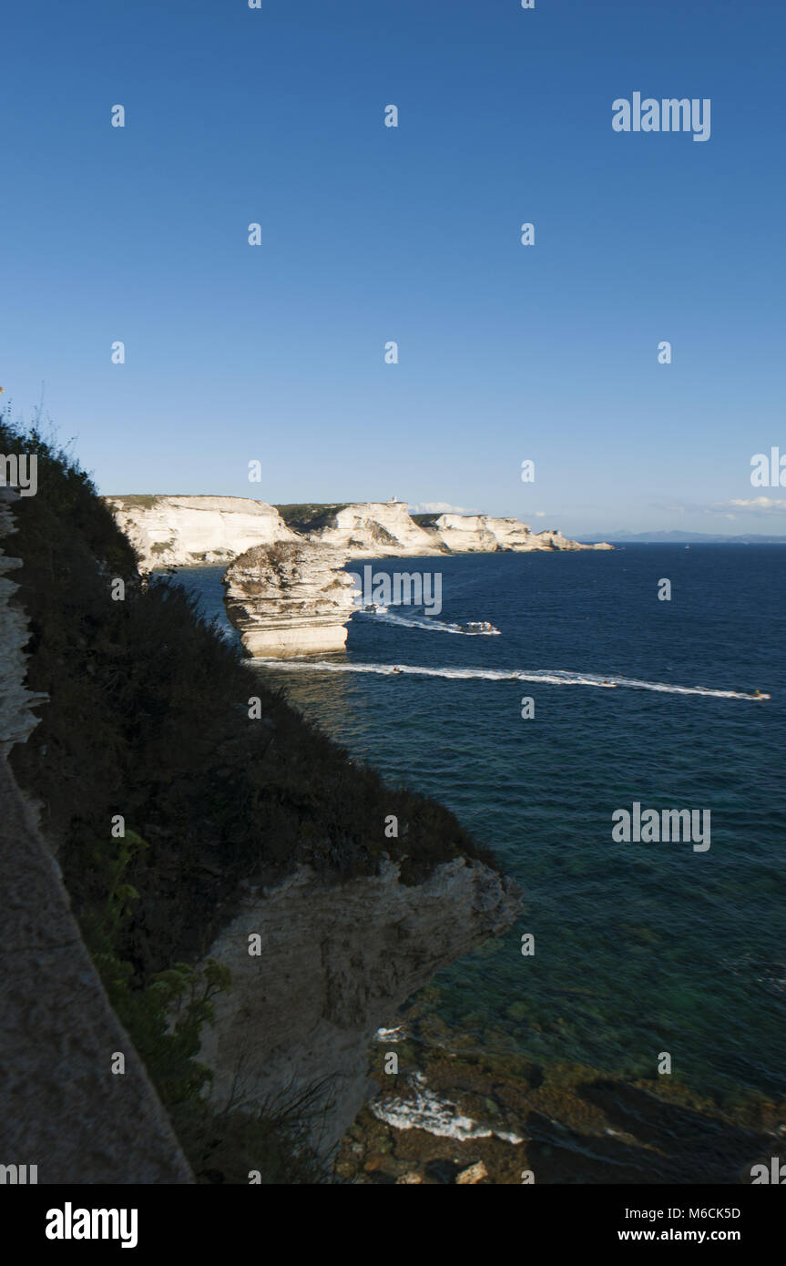 Corsica: la mozzafiato bianche scogliere calcaree nella International Bouches de Bonifacio parco marino con vista del capo Pertusato faro Foto Stock