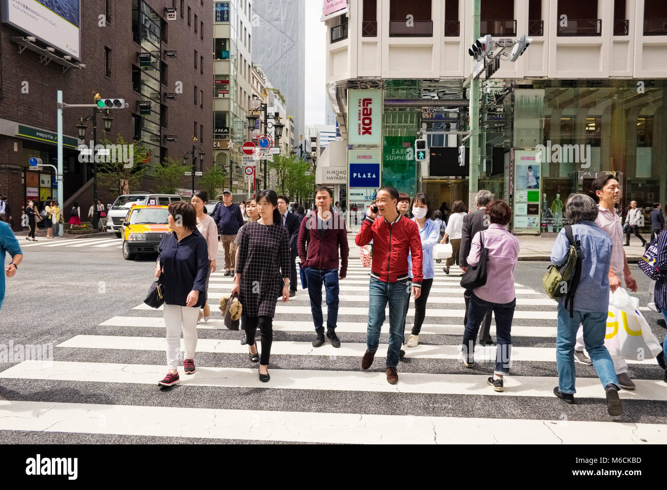 Persone su un attraversamento pedonale nel quartiere di Ginza di Tokyo city, Giappone Foto Stock