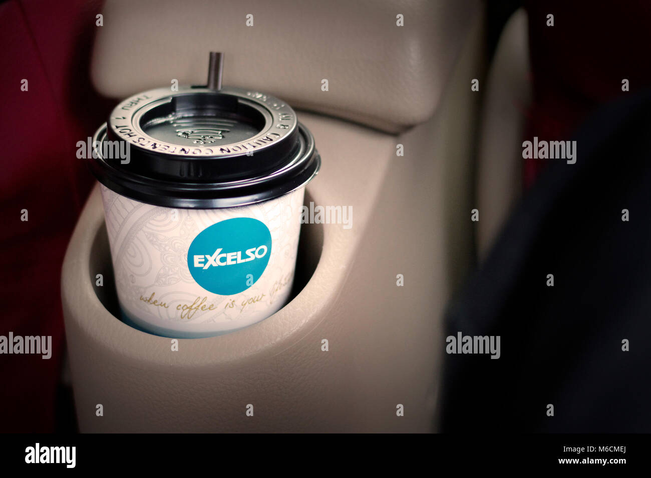 Una tazza di caffè excelso in auto, a bere la maniglia Foto Stock