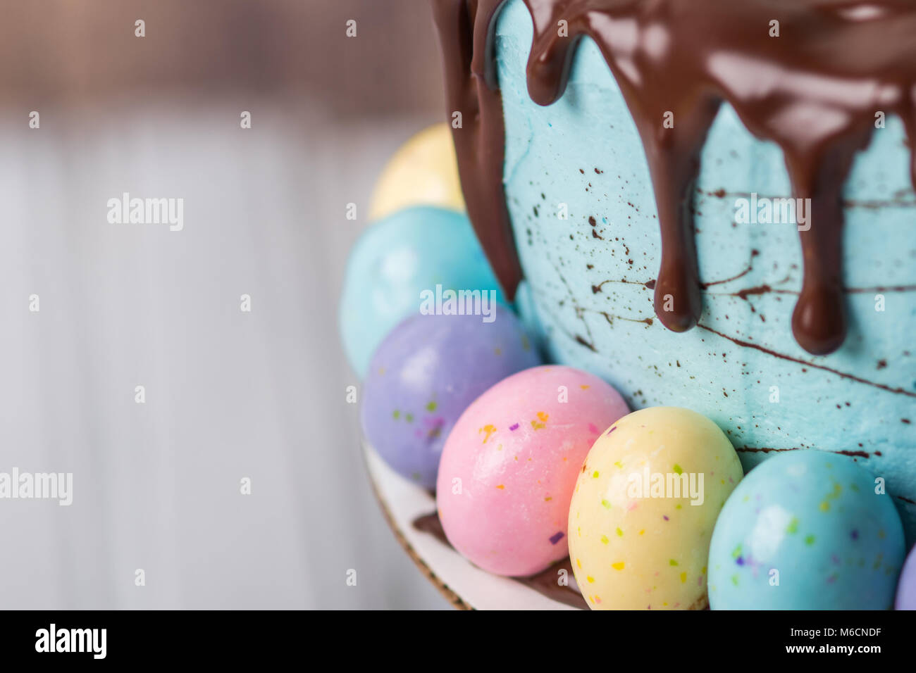 Torta di Pasqua con il blu di glassa di cioccolato e gocciolamento con uova di candy Foto Stock