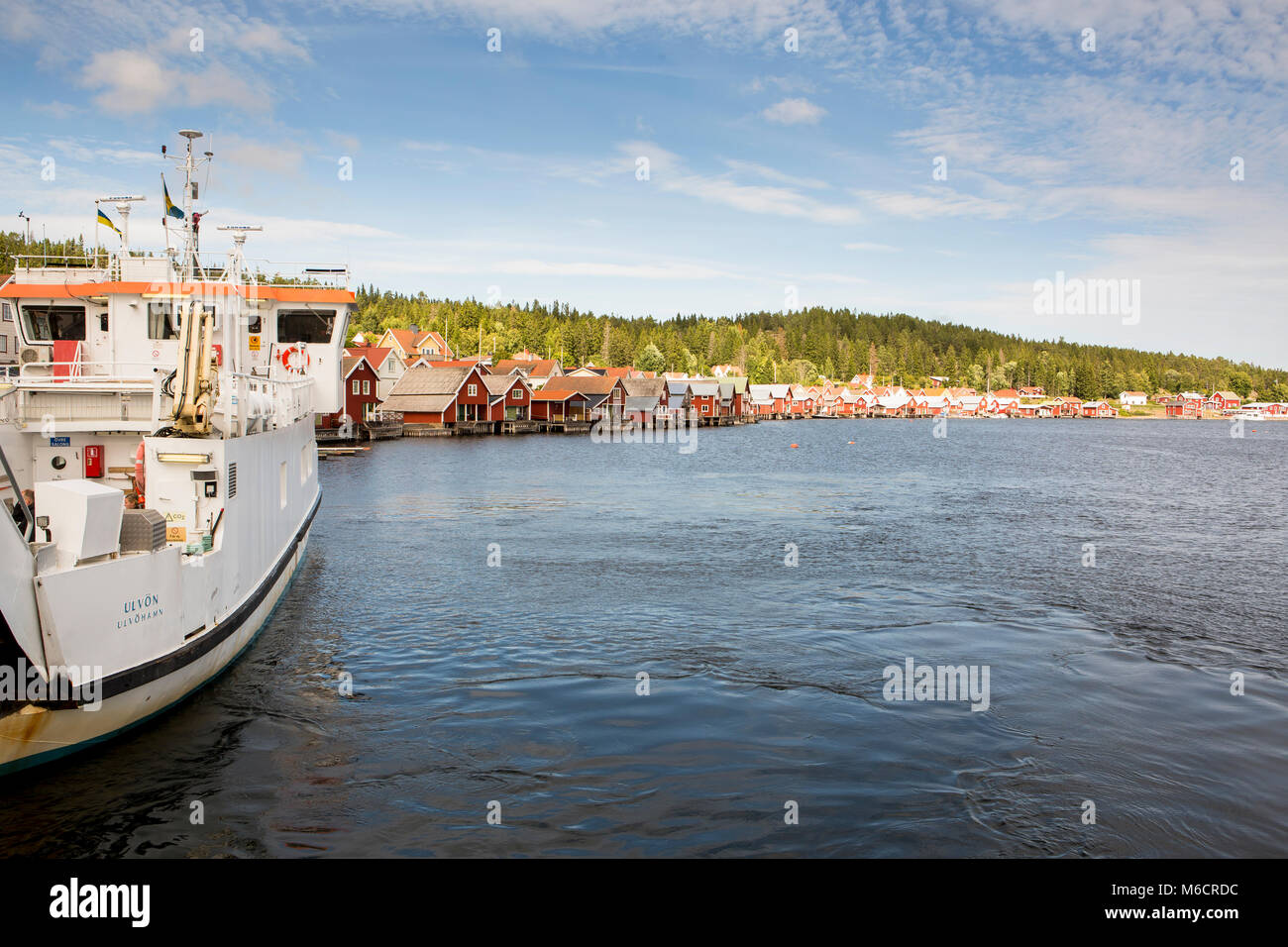 Il porto di Ulvon, Svezia, dove piccoli, rosso case di legno sono costruite in corrispondenza della linea di galleggiamento. Foto Stock