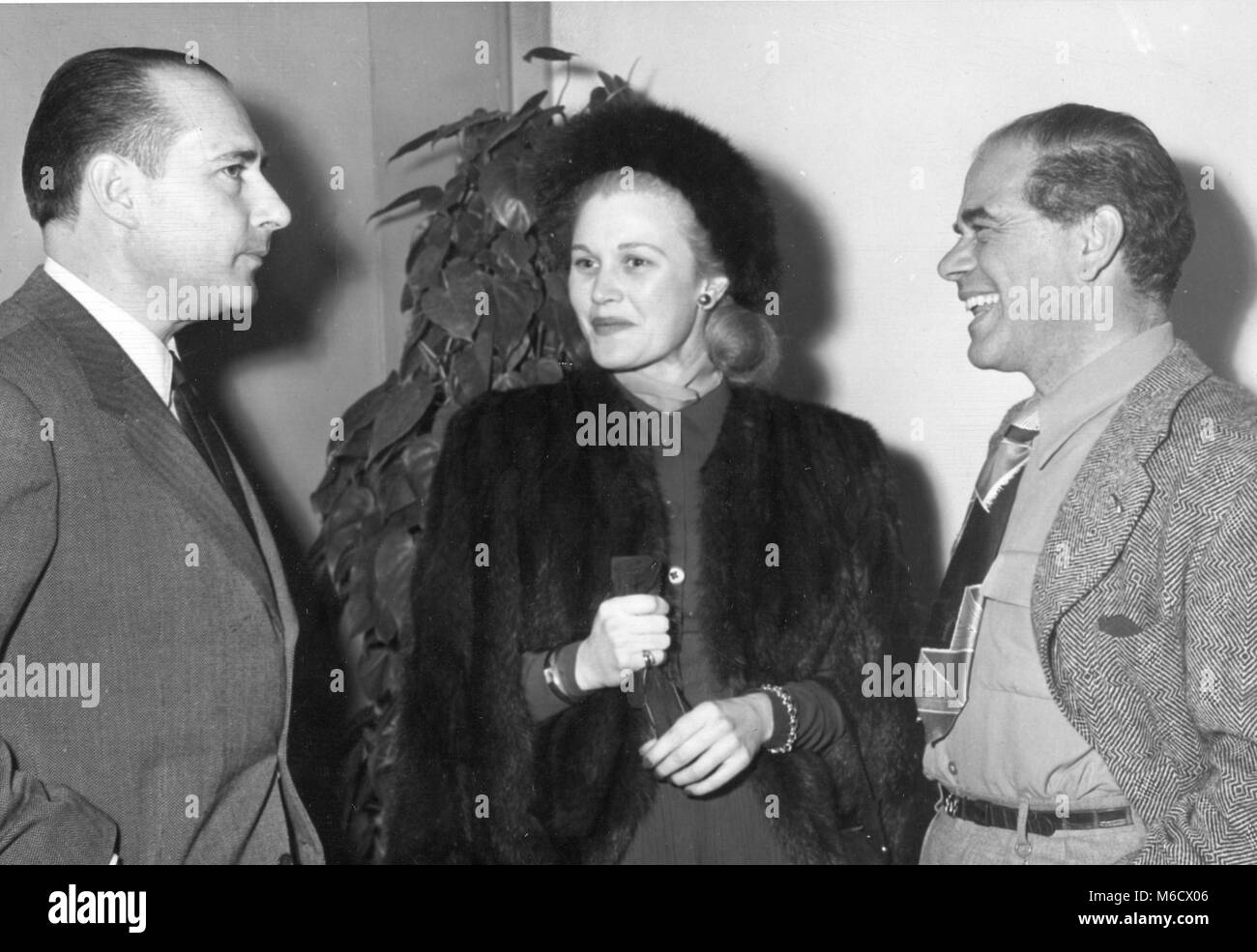 Roberto Rossellini (sinistra), famoso Italian motion picture director, colloqui con attrice cinematografica Joan Caulfield e regista Frank Capra a un pranzo in suo onore a Paramount Studios. Hollywood, CA, 1/31/49. Foto Stock