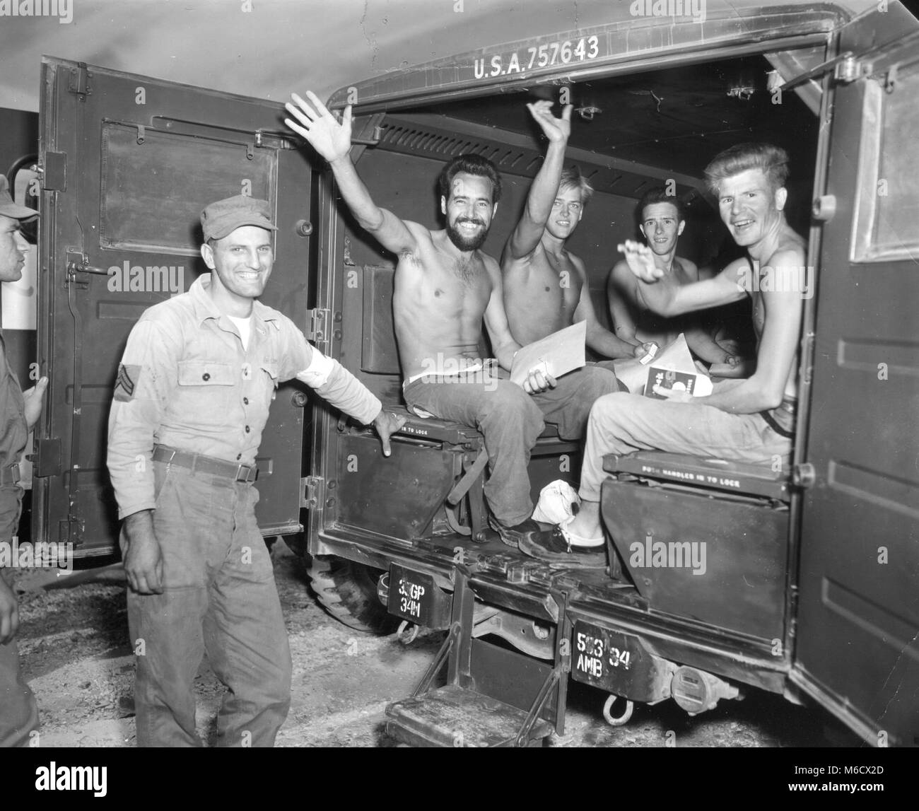 Giubilanti, rimpatriati americani prigionieri di guerra felicemente onda come essi aspettano la loro partenza in ambulanza per un centro di lavorazione sulla prima tappa del loro viaggio verso casa. Panmunjom, Corea, SETT 4. 1953. Stati Uniti Esercito Foto Stock