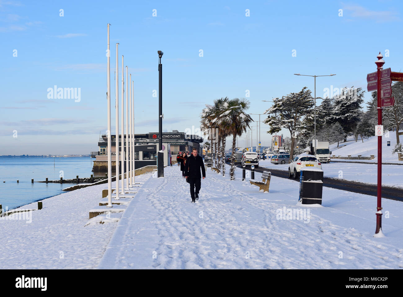 Persone che camminano per lavorare sulla neve sul lungomare di Southend durante la bestia del fenomeno meteorologico orientale. Macchine. Mare Foto Stock