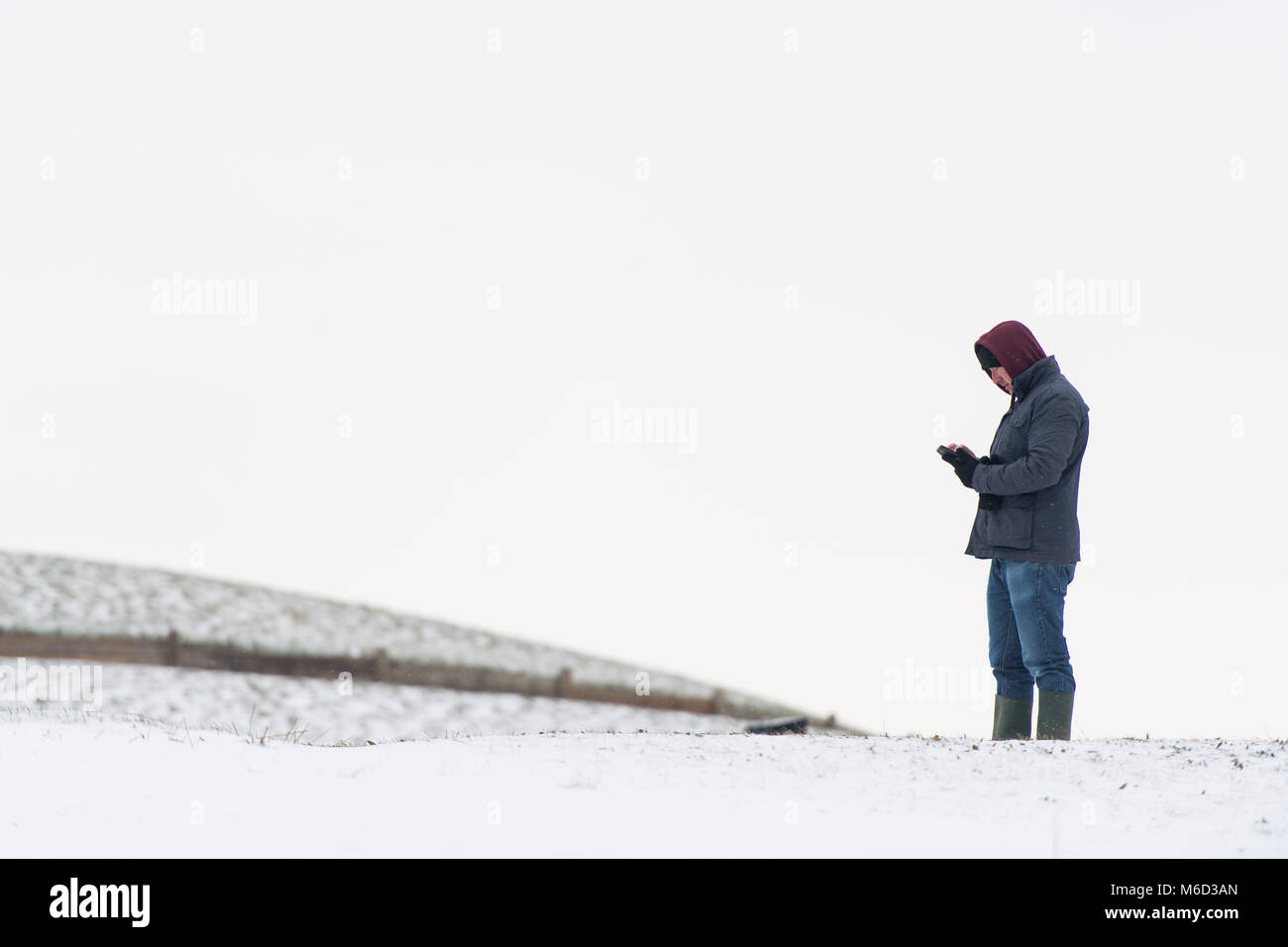 Penarth, Galles. 2 marzo 2018. Un uomo che usa il suo telefono in Penarth, vicino a Cardiff. Tempesta Emma e "La Bestia da est' hanno colpito il Regno Unito, con un allarme rosso per la neve e vento rilasciati per le aree circostanti Cardiff, Newport, il Galles del Sud delle Valli, e sud ovest dell'Inghilterra. Foto di Polly Thomas Credito: Polly Thomas/Alamy Live News Foto Stock