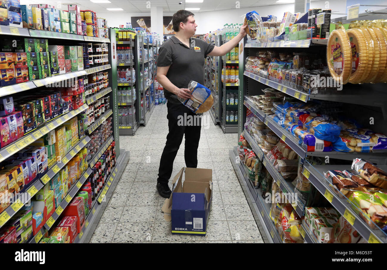 Il 15 febbraio 2018, Germania, Rostock: Benjamin Kneerich spacchetta merci presso Cap-Markt nel Seidelstrasse. Il fornitore soffre di una malattia metabolica ed un grado di disabilità del 40. Il concetto di funzionamento a livello nazionale Cap-Markt catena si trova in offerta disabili posti di lavoro simile a quelle sul mercato del lavoro in generale. Foto: Bernd Wüstneck/dpa Foto Stock