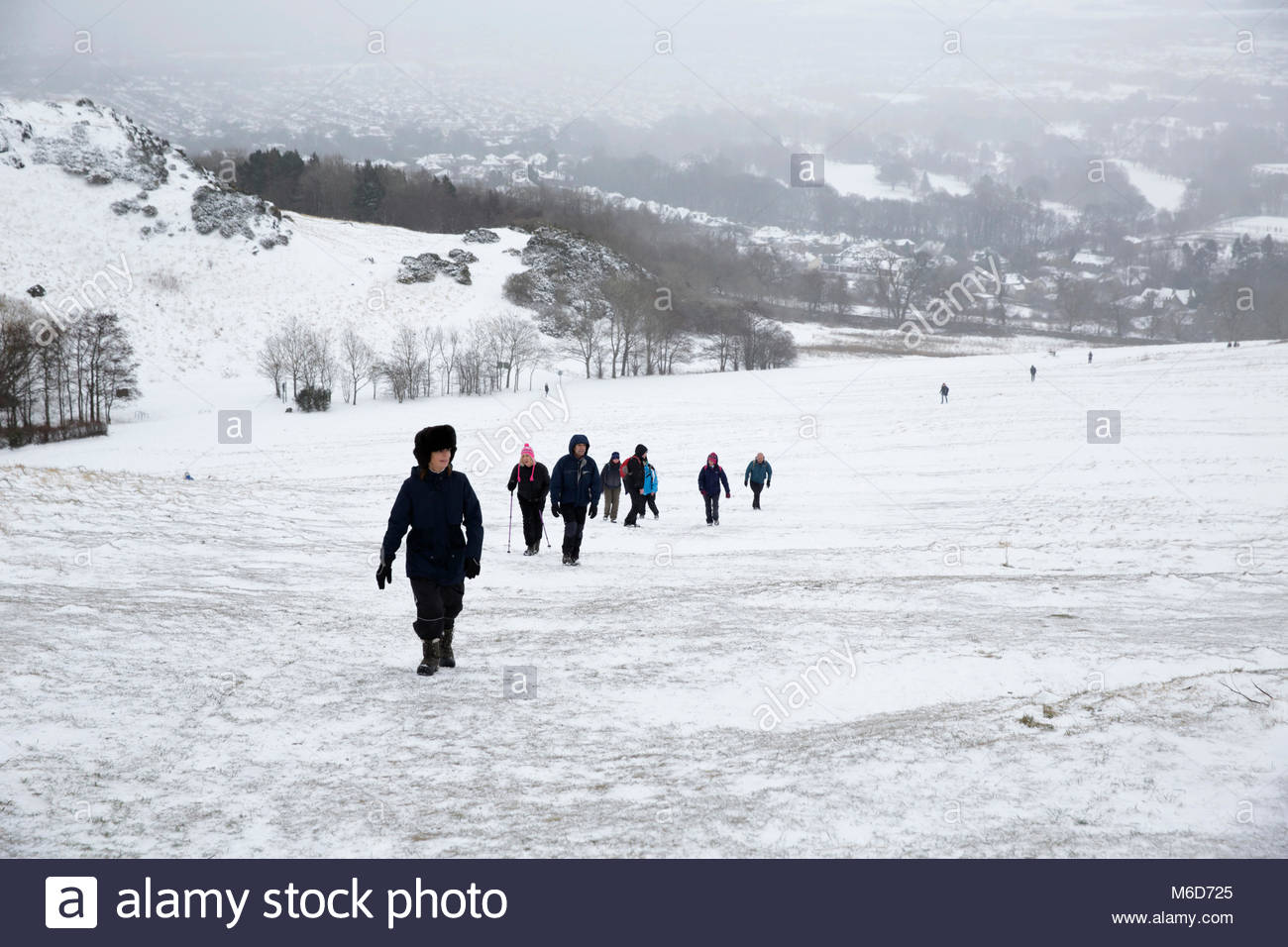 Edinburgh, Regno Unito. 2 Marzo, 2018. Nevicate invernali che colpiscono Arthur' Seat e Holyrood Park. Un gruppo di escursionisti verso l'alto sulla salita di Arthur Seat. Est e Sud Edimburgo in background. Credito: Craig Brown/Alamy Live News. Foto Stock