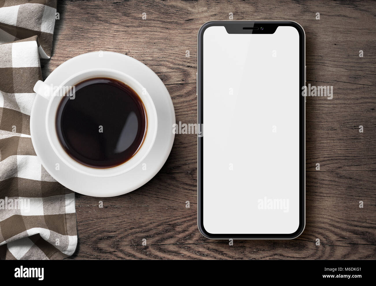 Nuovo smartphone simile a iphone X vista dall'alto su bianco scrivania di legno con tazza di caffè e panno per pulizia Foto Stock