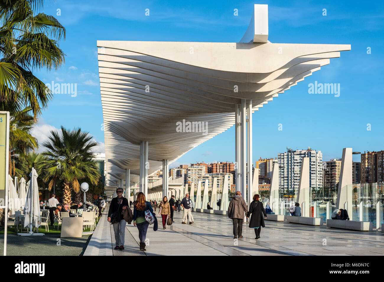 Malaga, Spagna - 7 Dicembre 2016: Le persone sono a piedi lungo il terrapieno (Paseo Del Muelle Dos Promenade) che si estende attraverso la porta sotto un constr Foto Stock