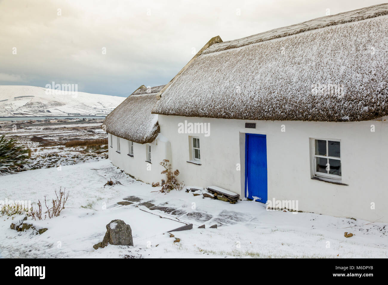 Neve coperti in paglia cottage irlandese in Vicolo del paese sull' isola Valentia, nella contea di Kerry, Irlanda Foto Stock