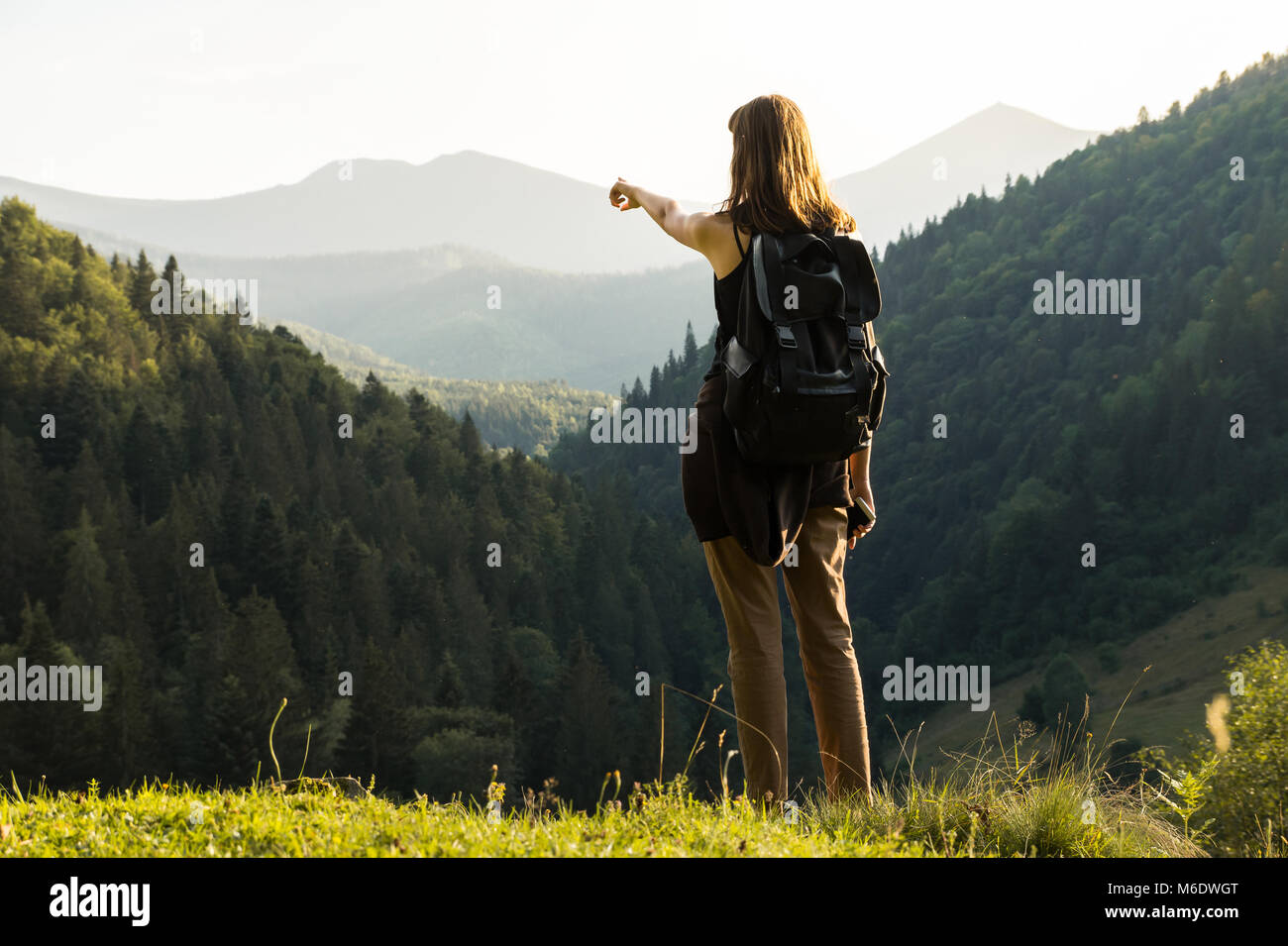 Giovani femmine backpacker sorge in cima alla collina in ucraino Carpazi e punti di picco di destinazione Foto Stock