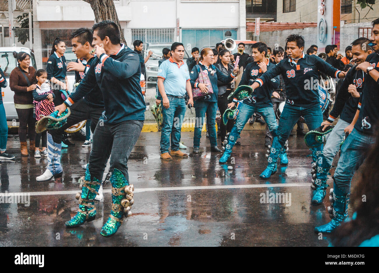 Cochabamba Bolivia - Febbraio 2018: Caporales gruppi di ballerini sfilano per le strade piovose in un pre-sfilata di carnevale Foto Stock