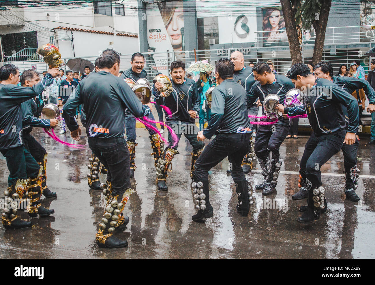 Cochabamba Bolivia - Febbraio 2018: Caporales gruppi di ballerini sfilano per le strade piovose in un pre-sfilata di carnevale Foto Stock