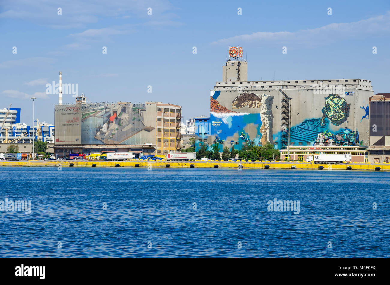 Porto del Pireo, Grecia - Maggio 30, 2017: Silo e dei bacini di carenaggio di edifici con la pittura murale vicino a silos Ietioneias costa con il suo museo galleggiante "L'Hôtel Foto Stock
