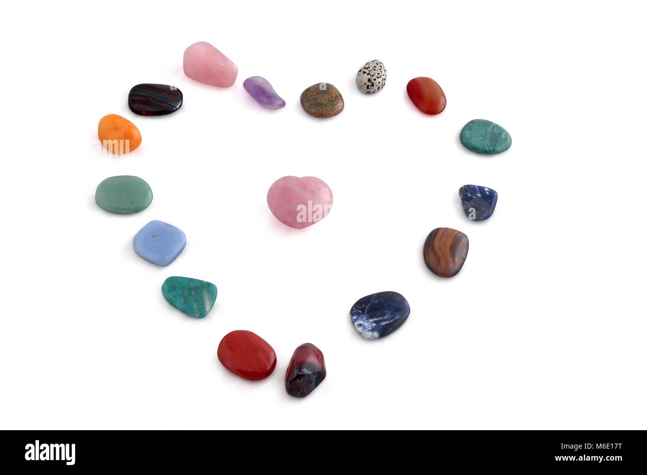 Piccoli cristalli trasformati disposte a forma di cuore, vari tipi, su sfondo bianco Foto Stock