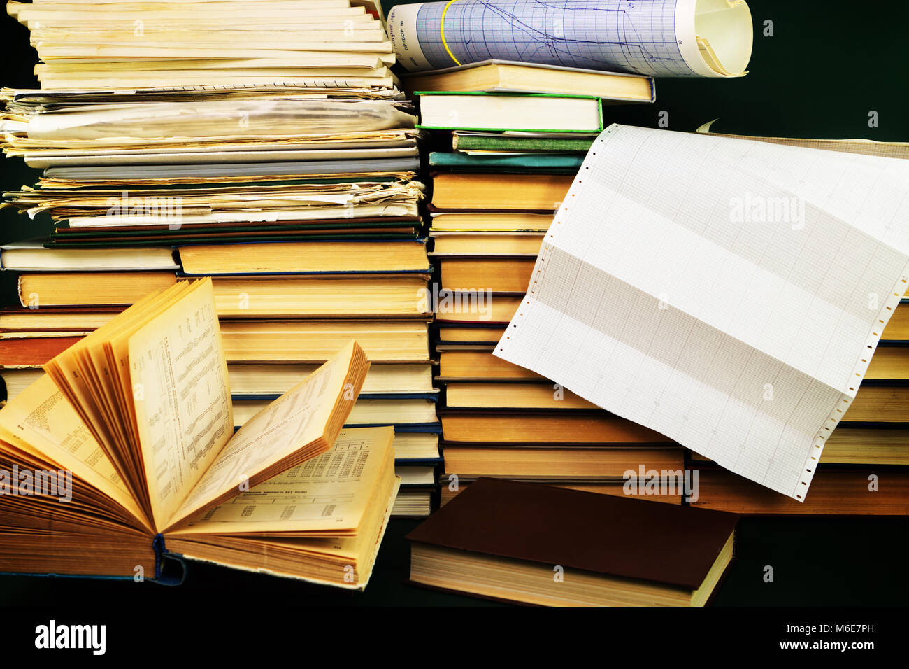 Lo studio scientifico. Un libro aperto e lo schema sulla scrivania sullo sfondo di uno scaffale con libri Foto Stock