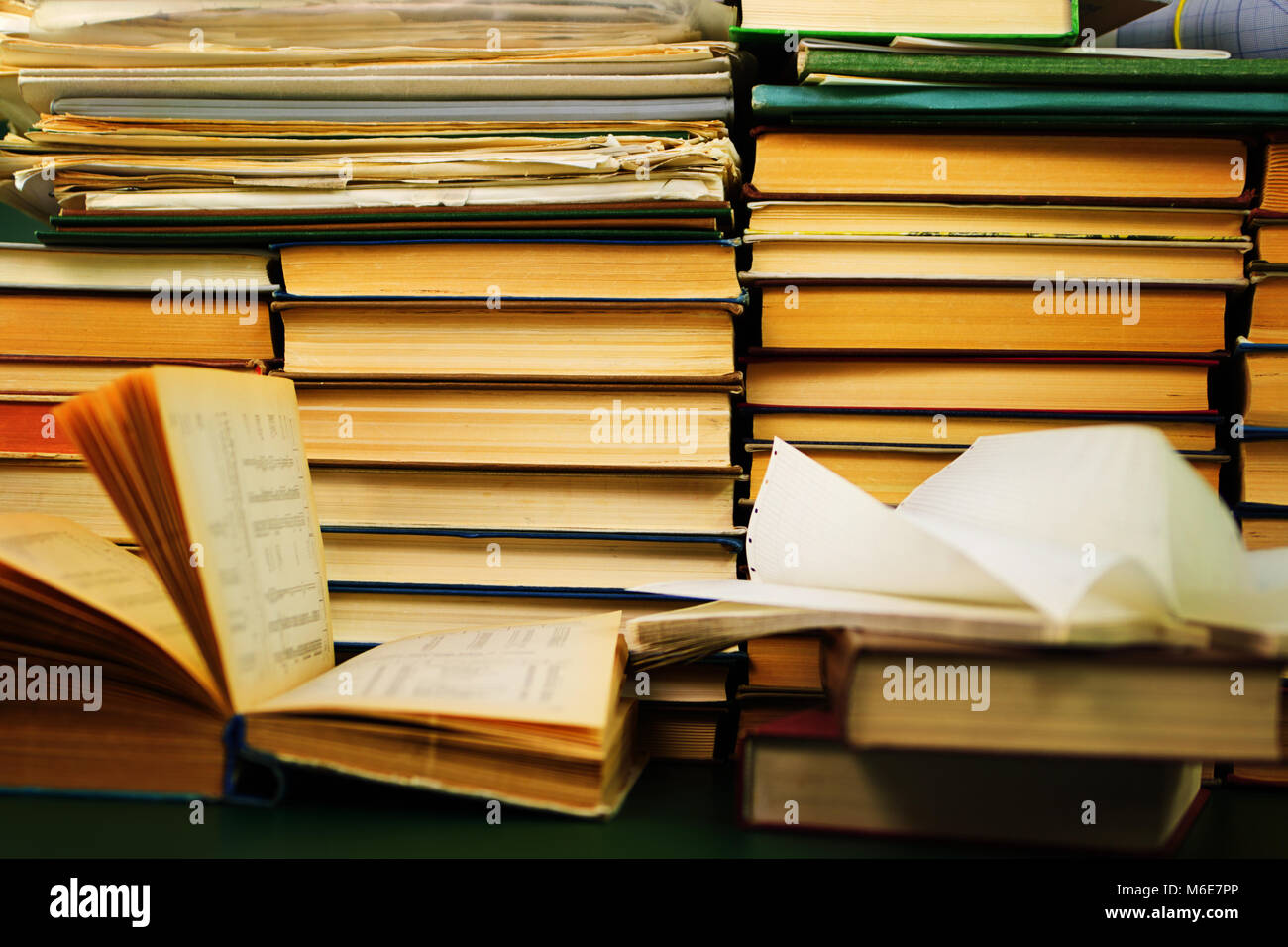 Lo studio scientifico. Un libro aperto e lo schema sulla scrivania sullo sfondo di uno scaffale con libri Foto Stock