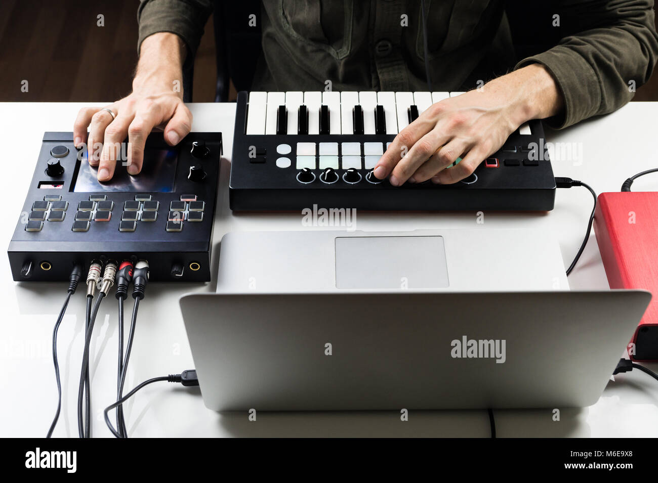 Persona di sesso maschile il controllo o la miscelazione di musica elettronica via su computer con aiuto del moderno effetto i processori e i controller di software Foto Stock