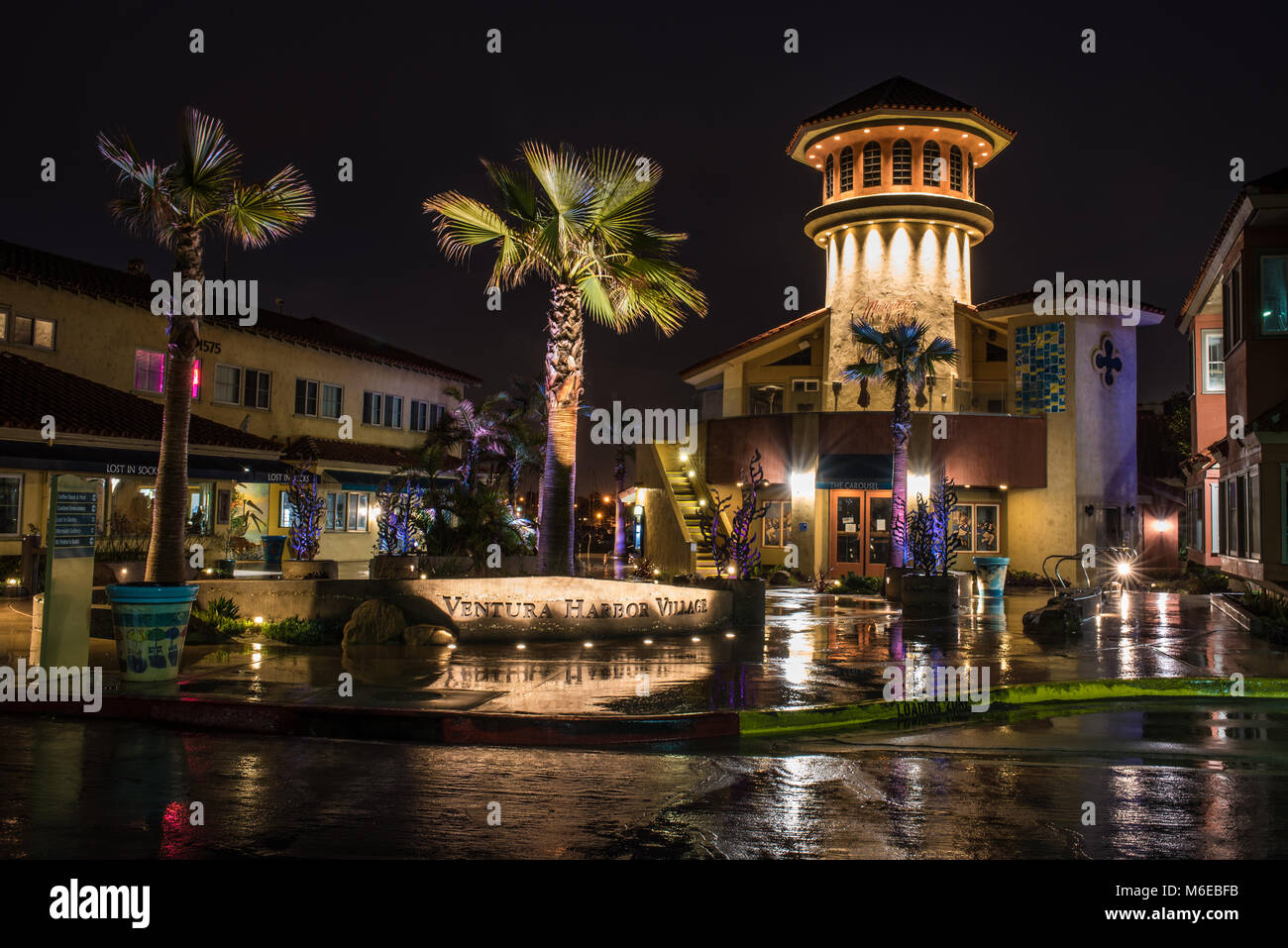Ventura Harbour Village in California, Stati Uniti bagnato e riflettendo la mattina le luci spot di area dello shopping in predawn ore di marzo, 2018. Foto Stock