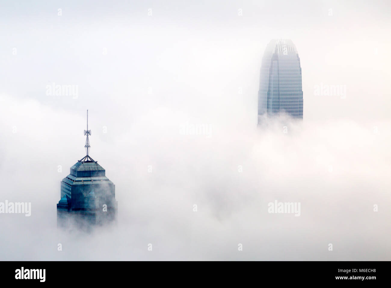 I foggy skyline di Hong Kong. Molti edifici sono coperti quando visto dalla vetta. Solo i più alti grattacieli possono avere la loro parte superiore visibile. Foto Stock